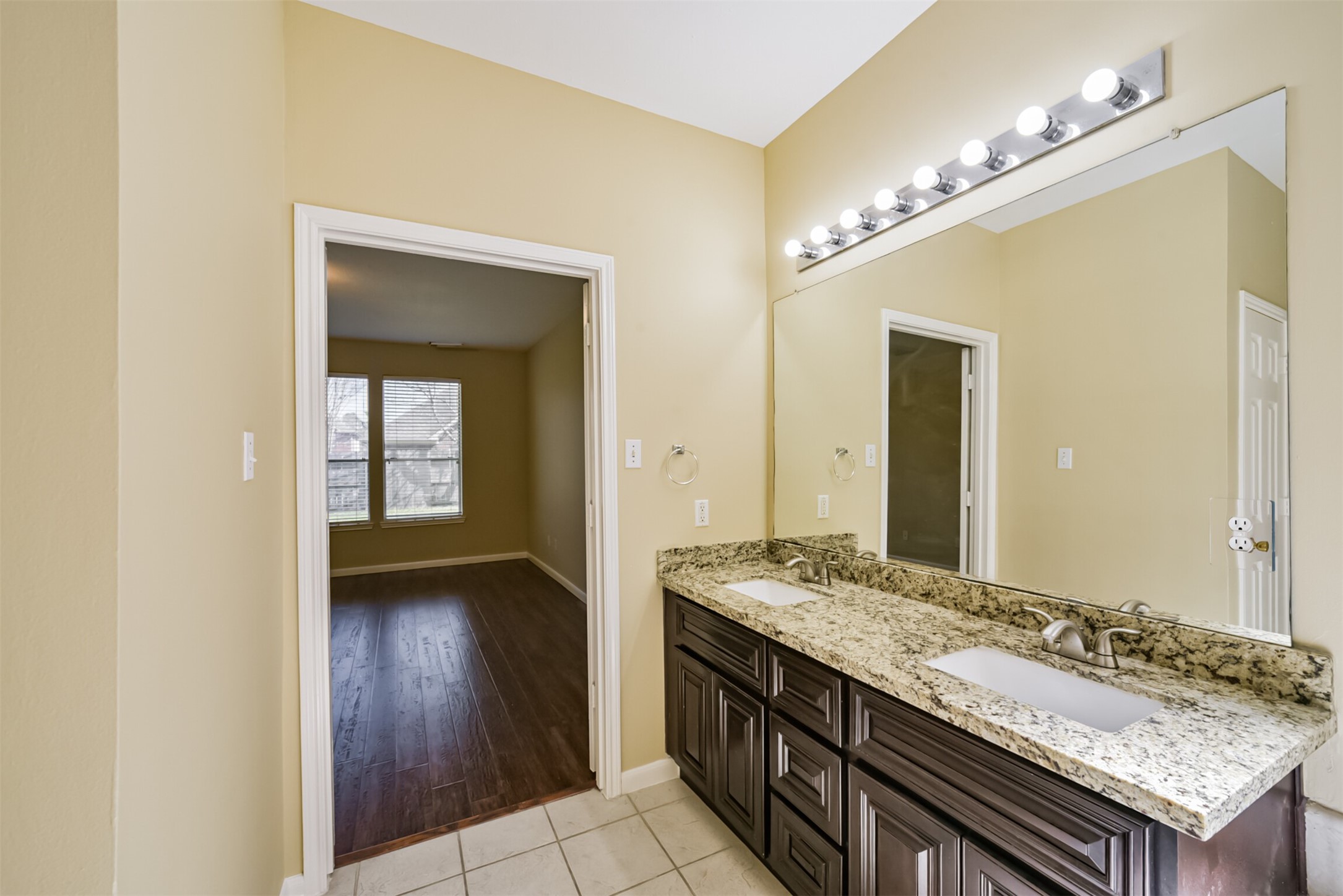 Primary bath with dual sinks, connecting directly to the primary bedroom.