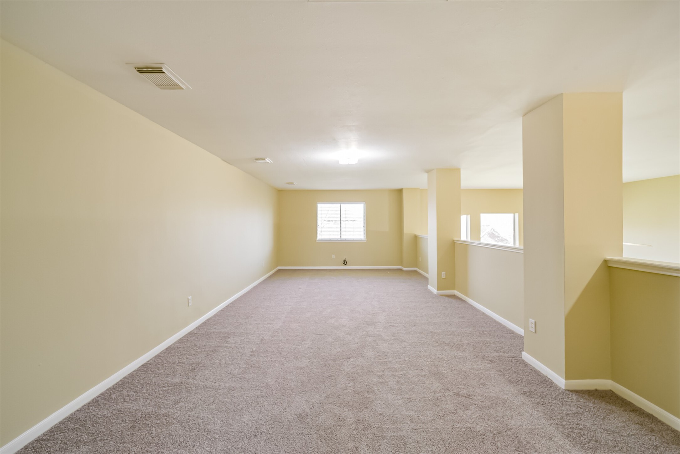 Upstairs den, open to the bonus room, with space for a TV area, seating, or workspace.