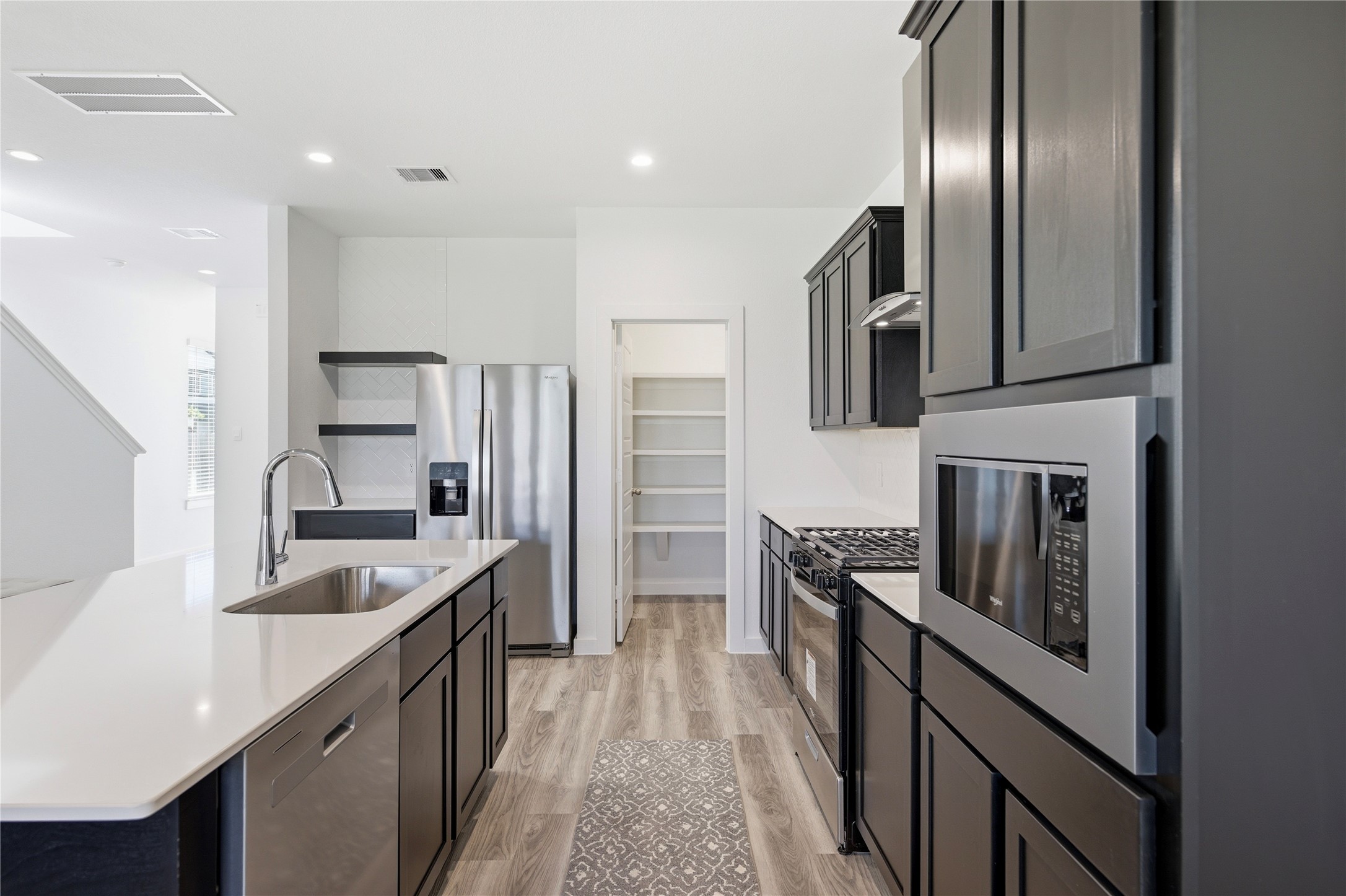 Stainless steel appliances and walk in pantry.