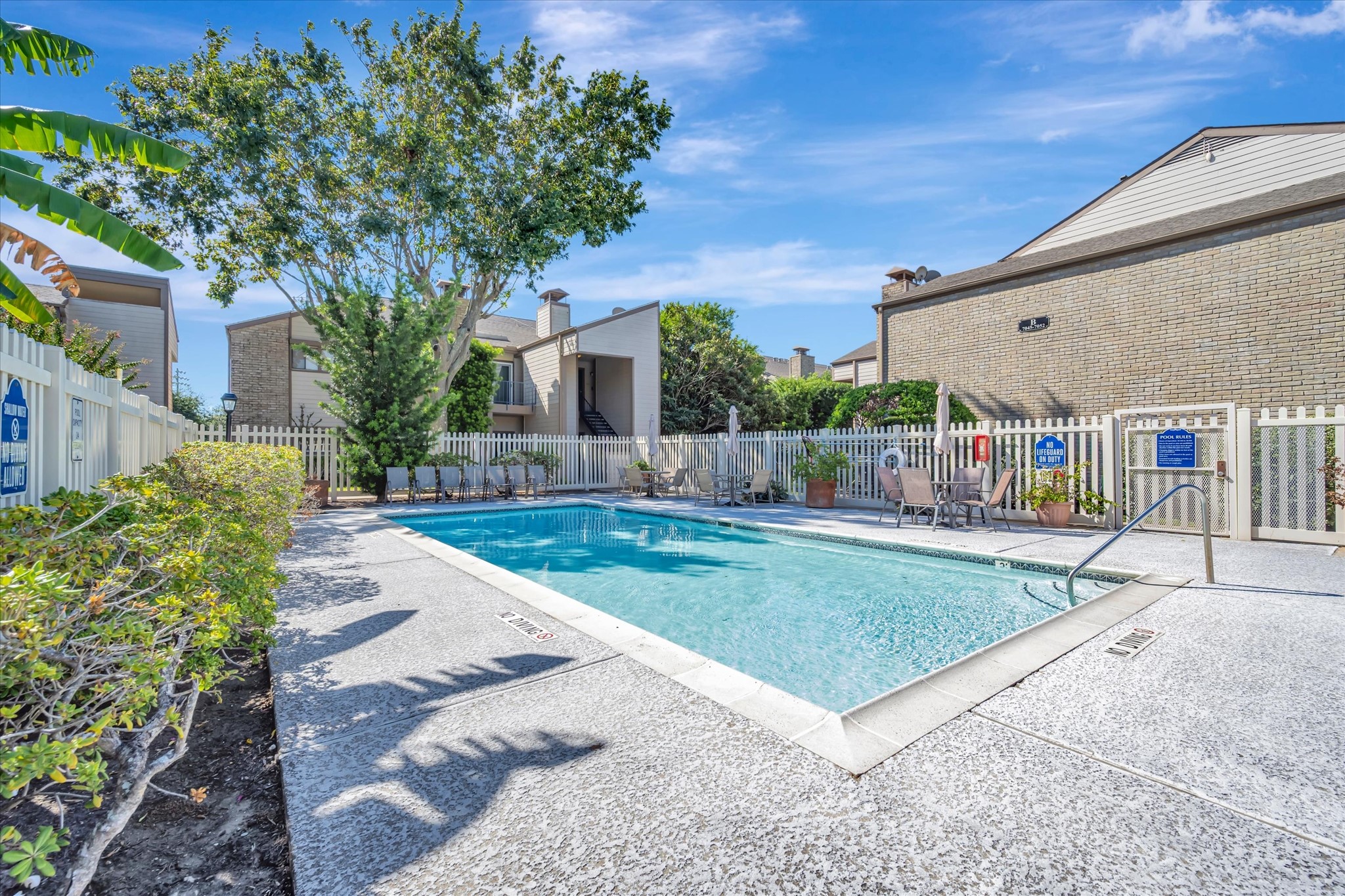 Community swimming pool with a surrounding deck and landscaped setting.