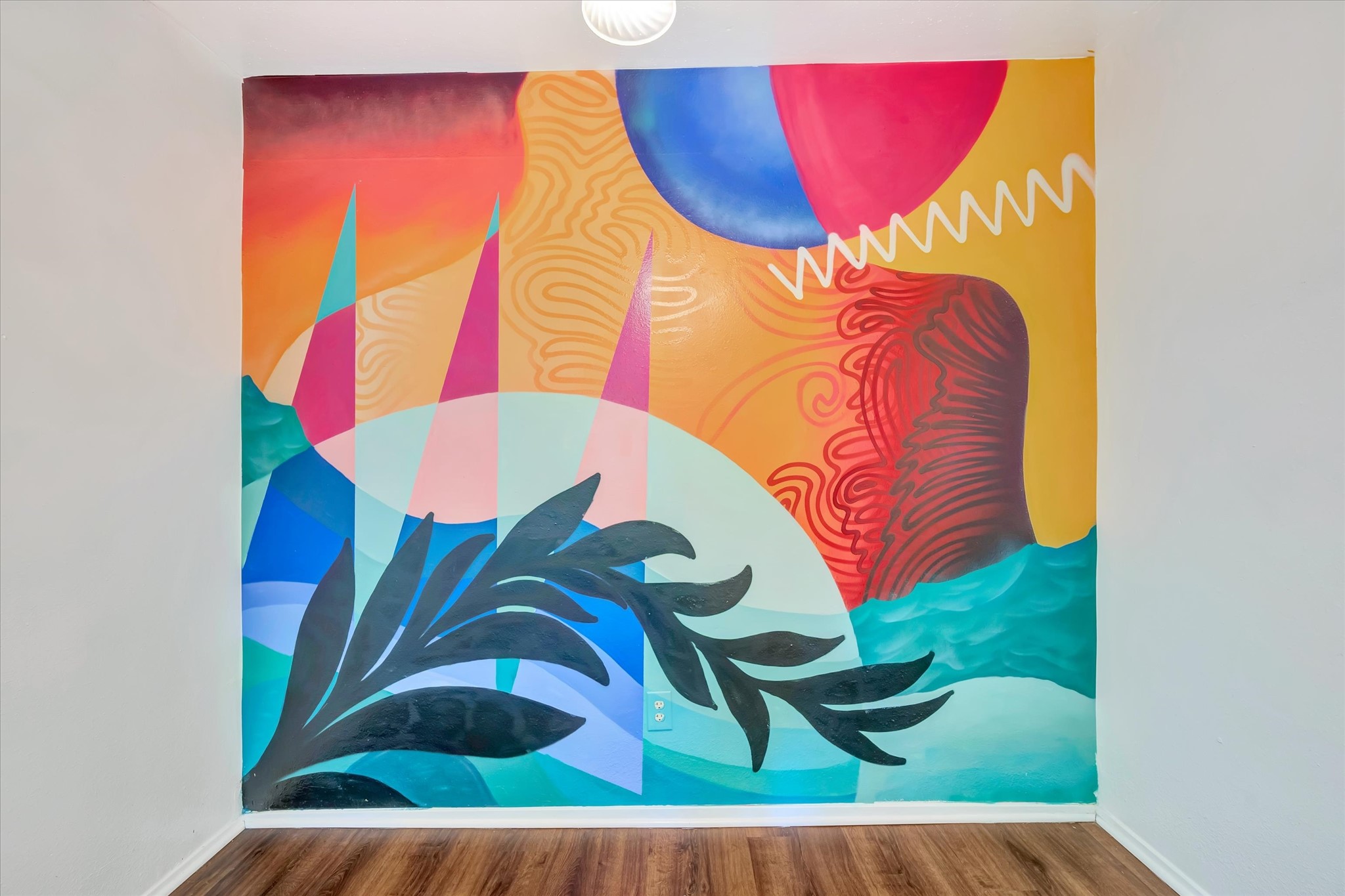 Custom mural by Galveston artist Gabriel Prusmack, painted for the owner, adds vibrant color and distinctive island character to the dining area.