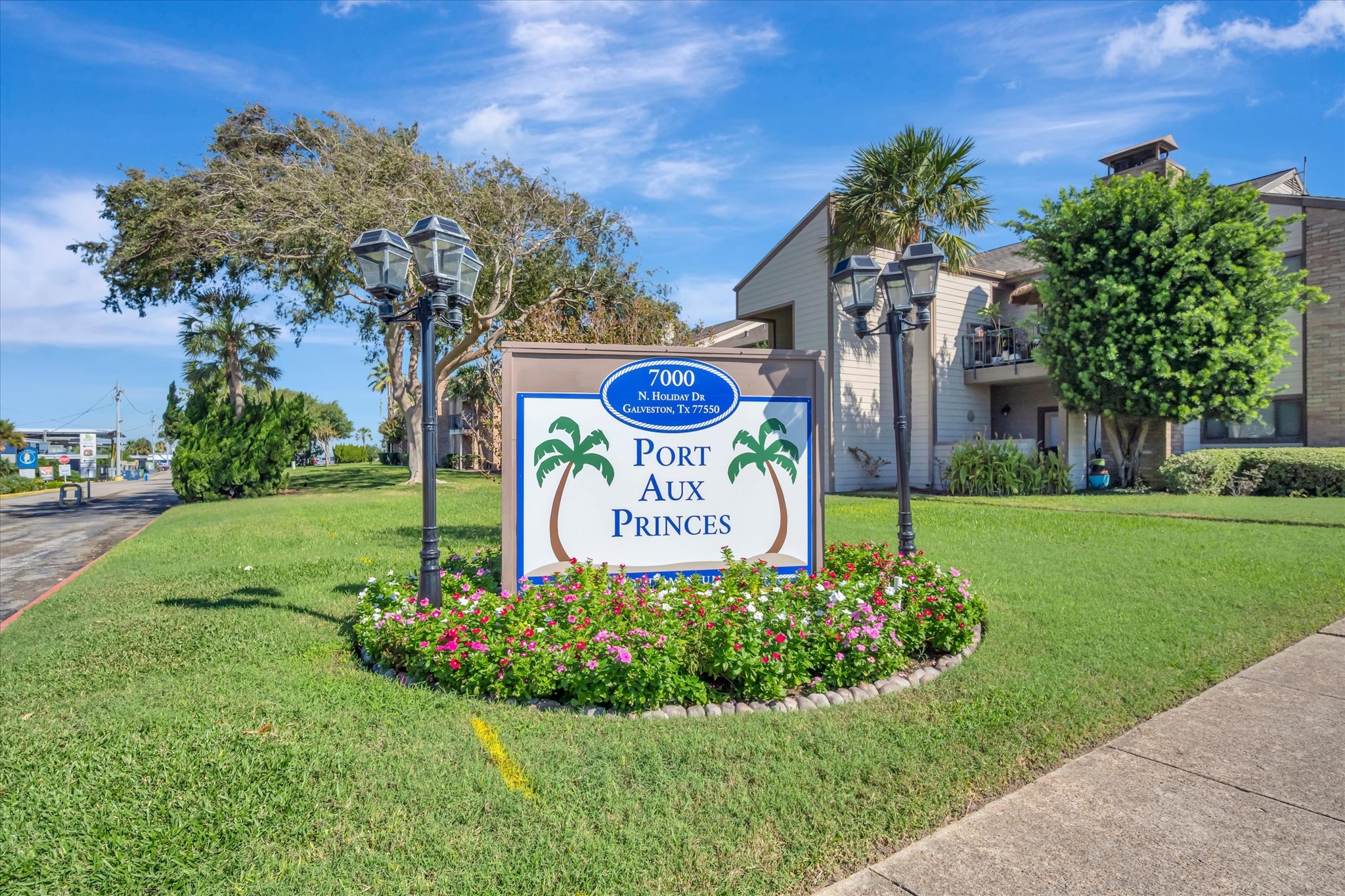 Landscaped community entrance with established trees and signage.