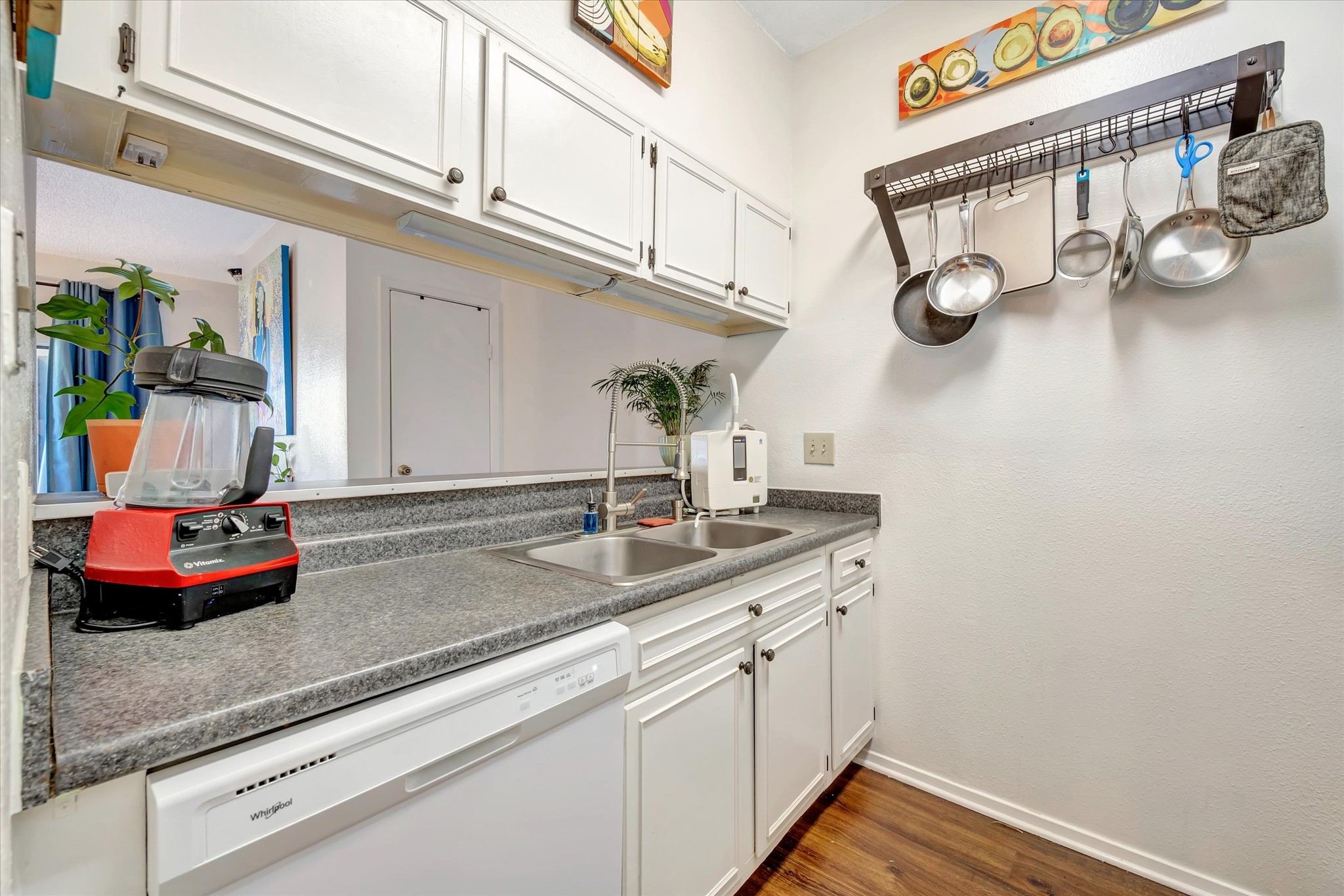 Kitchen with white cabinetry, countertop workspace and a window above the sink.