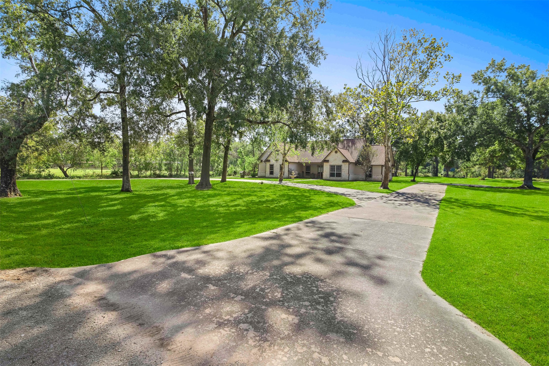 View of the front of the home with circle driveway and plenty of parking space. **Grass virtually enhanced**