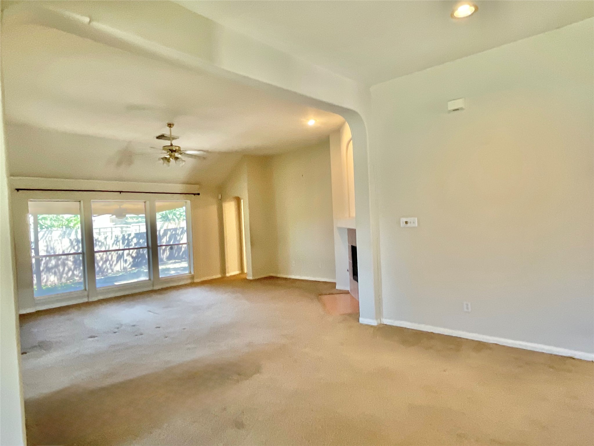 Dining room view into family room, fireplace and primary bedroom door Dining room view into family room, fireplace and primary bedroom door