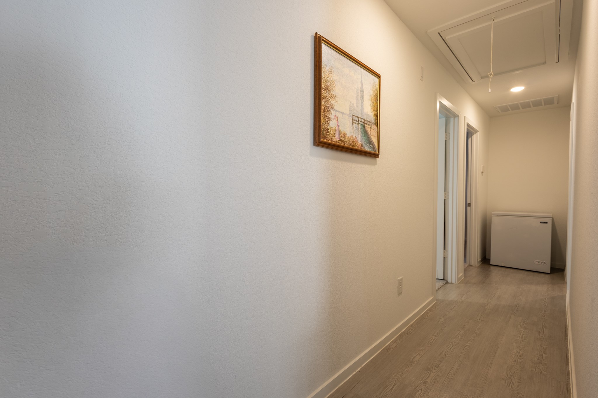 Convenient access to the auxiliary wing of the home, leading down to the secondary bedrooms and full guest bathroom.