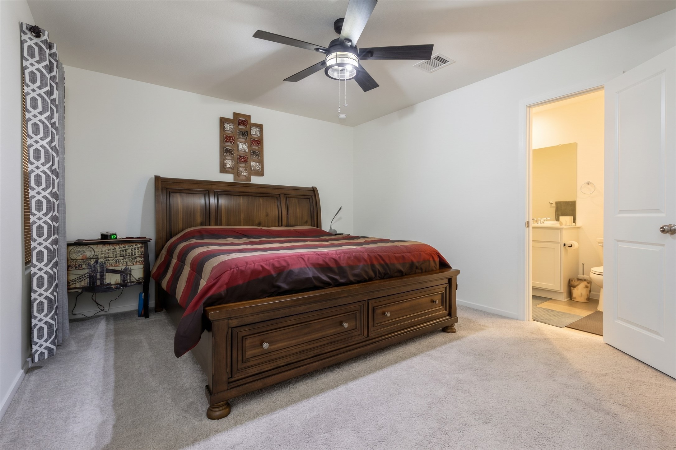 Tucked away for optimal privacy, the spacious primary suite features a beautiful layout, custom blinds, a cooling ceiling fan, and an en-suite bath.