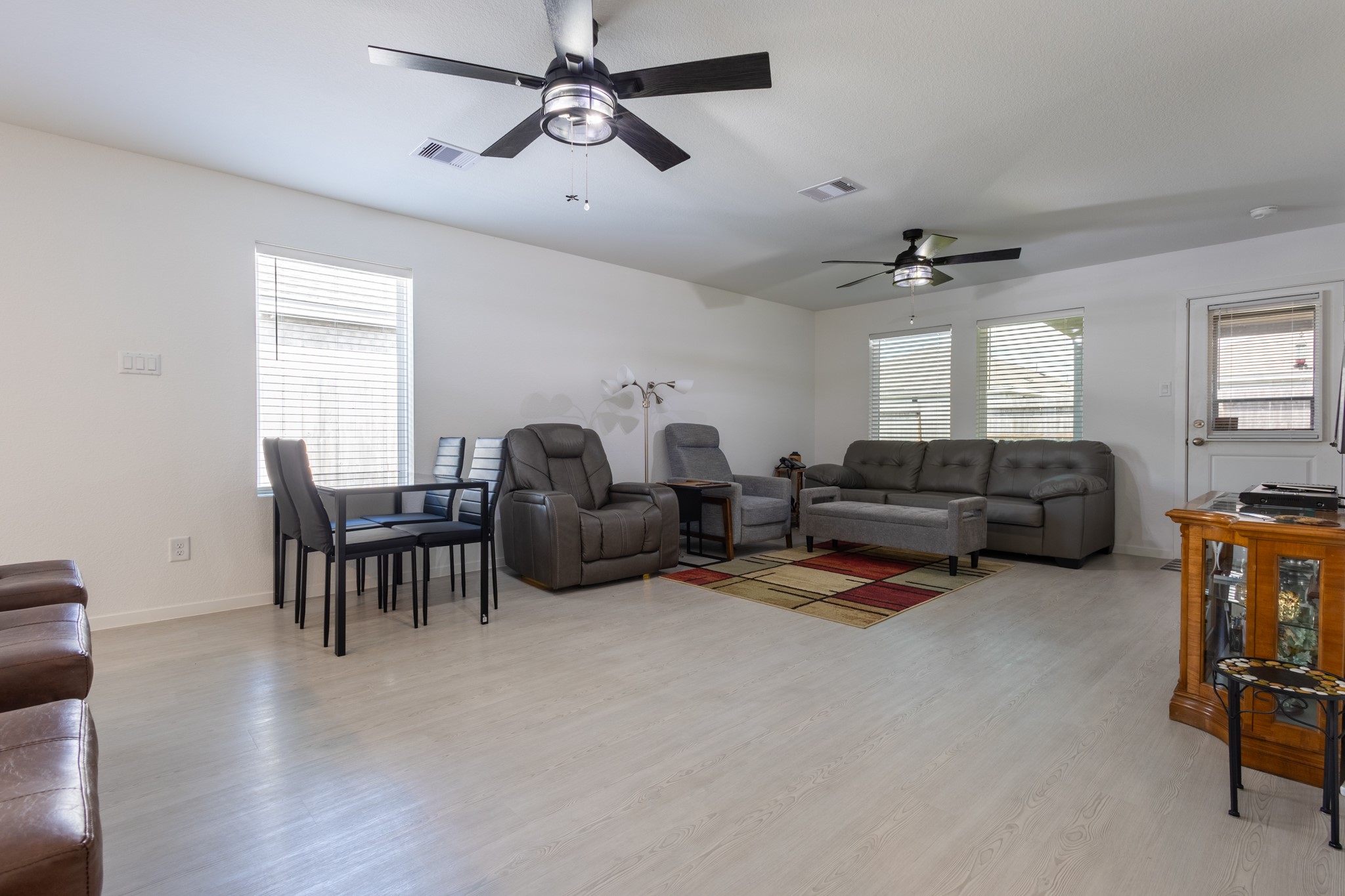 A cozy, relaxed family room view highlighting the large windows that frame the backyard oasis while providing effortless indoor-outdoor flow.
