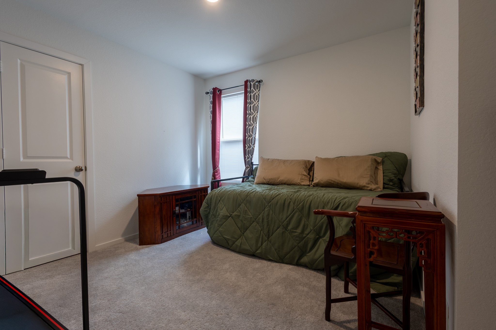 A bright, spacious secondary bedroom outfitted with a custom window blind and premium ceiling fanperfect for kids, guests, or a home office.