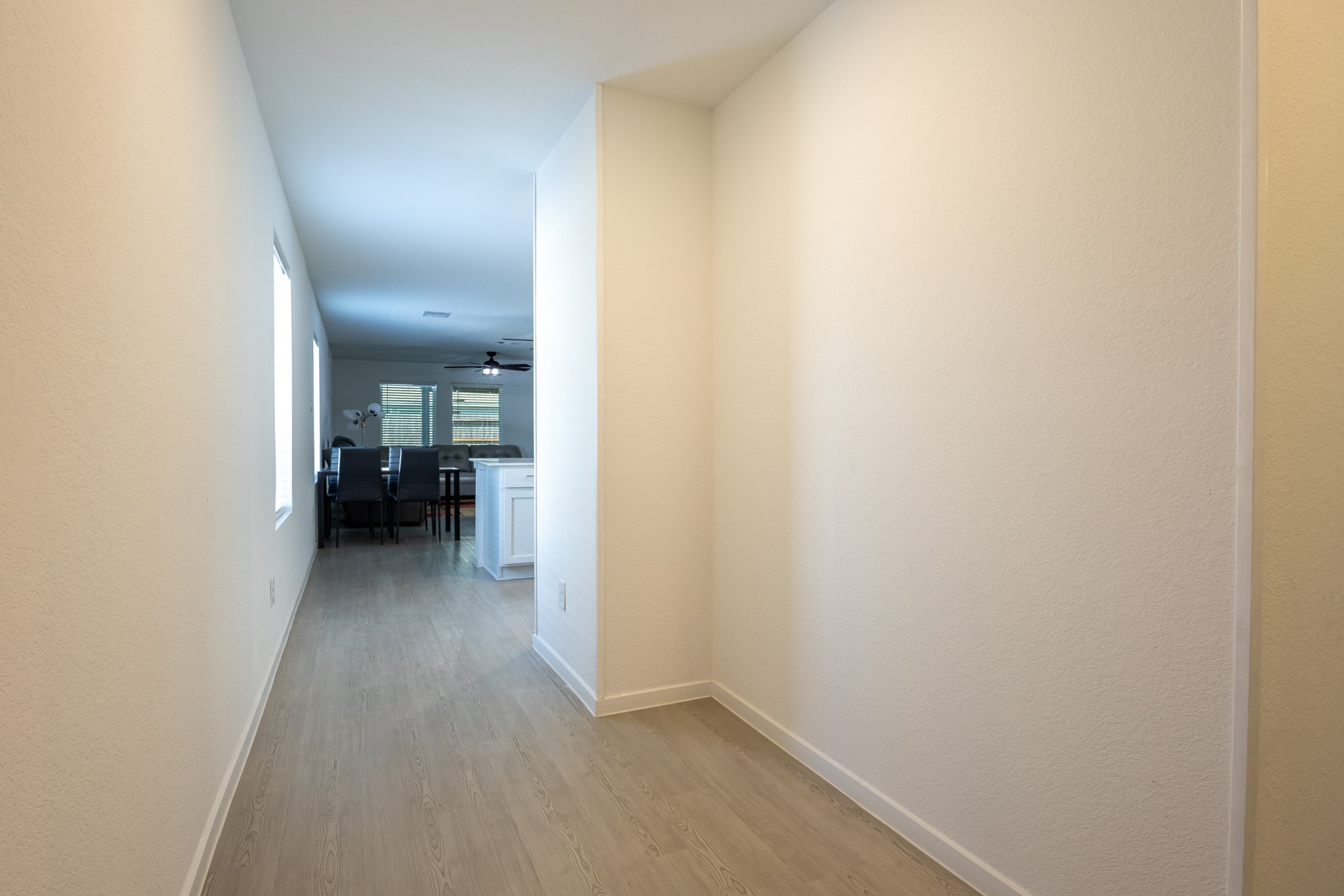 A seamless, extended entry hallway boasting durable, modern flooring that guides you gracefully into the heart of the home's open-concept layout.