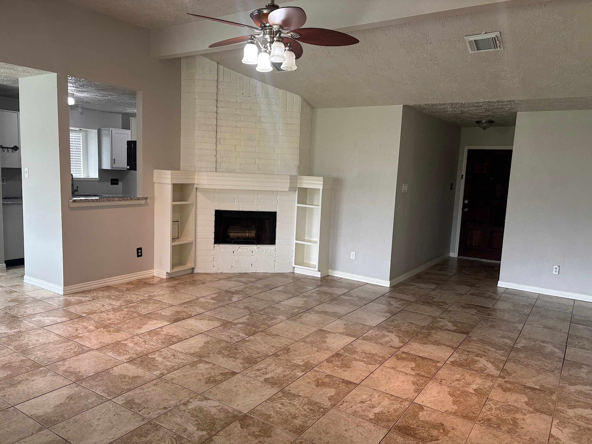 Elevate your living space with a charming fireplace and built-in shelves, adding warmth and style.