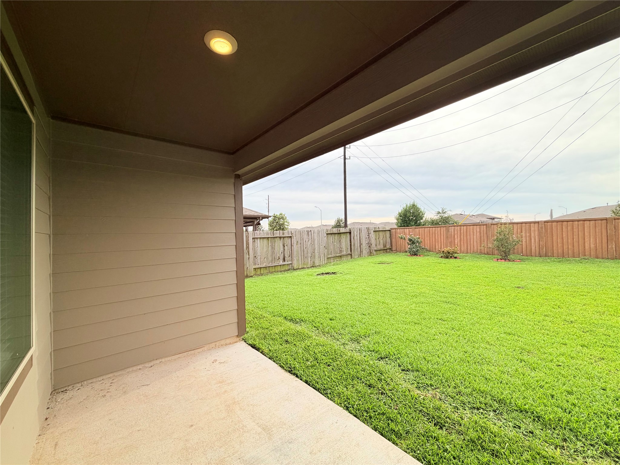 Covered patio overlooks the spacious backyard- perfect for relaxing, grilling or entertaining.