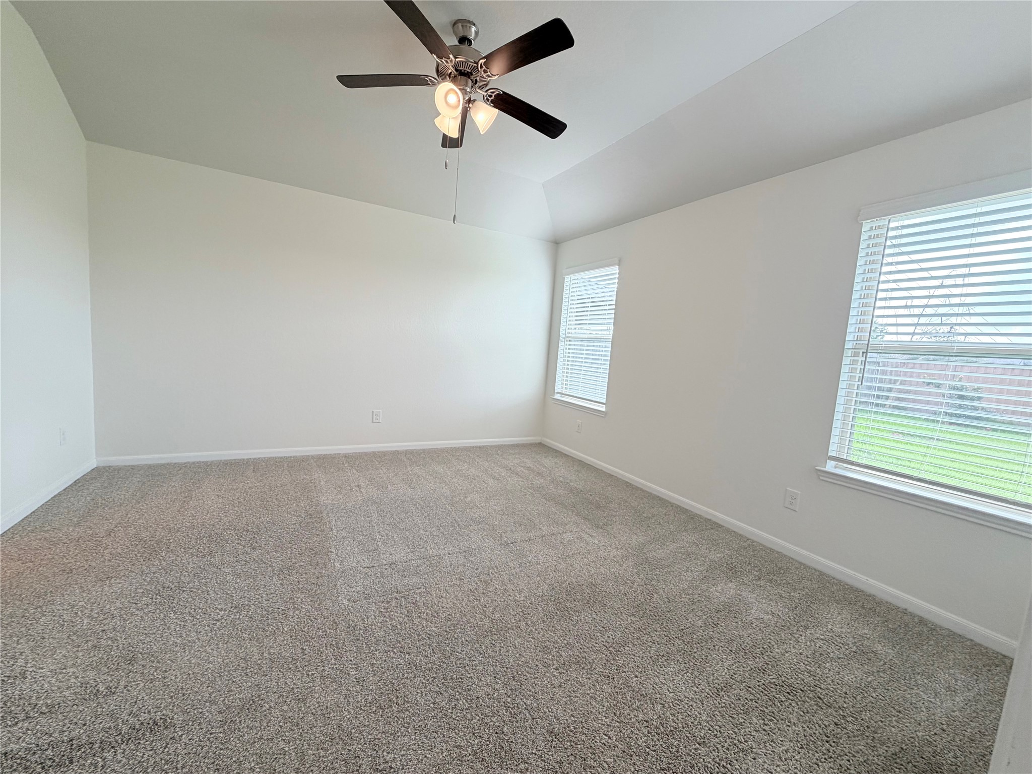 Private primary suite features large windows overlooking the backyard.