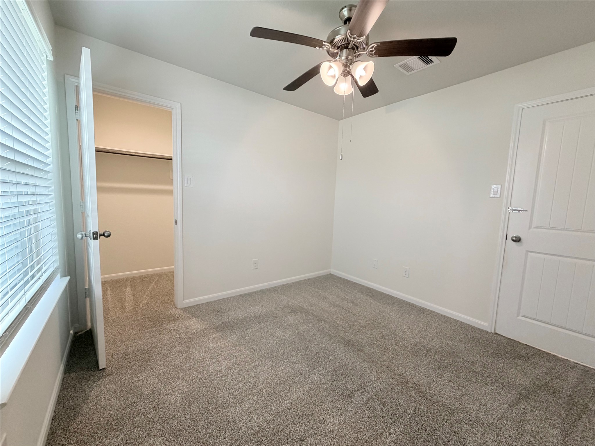 Bedroom 2 has a walk in closet, ceiling fan  and a window facing the front.