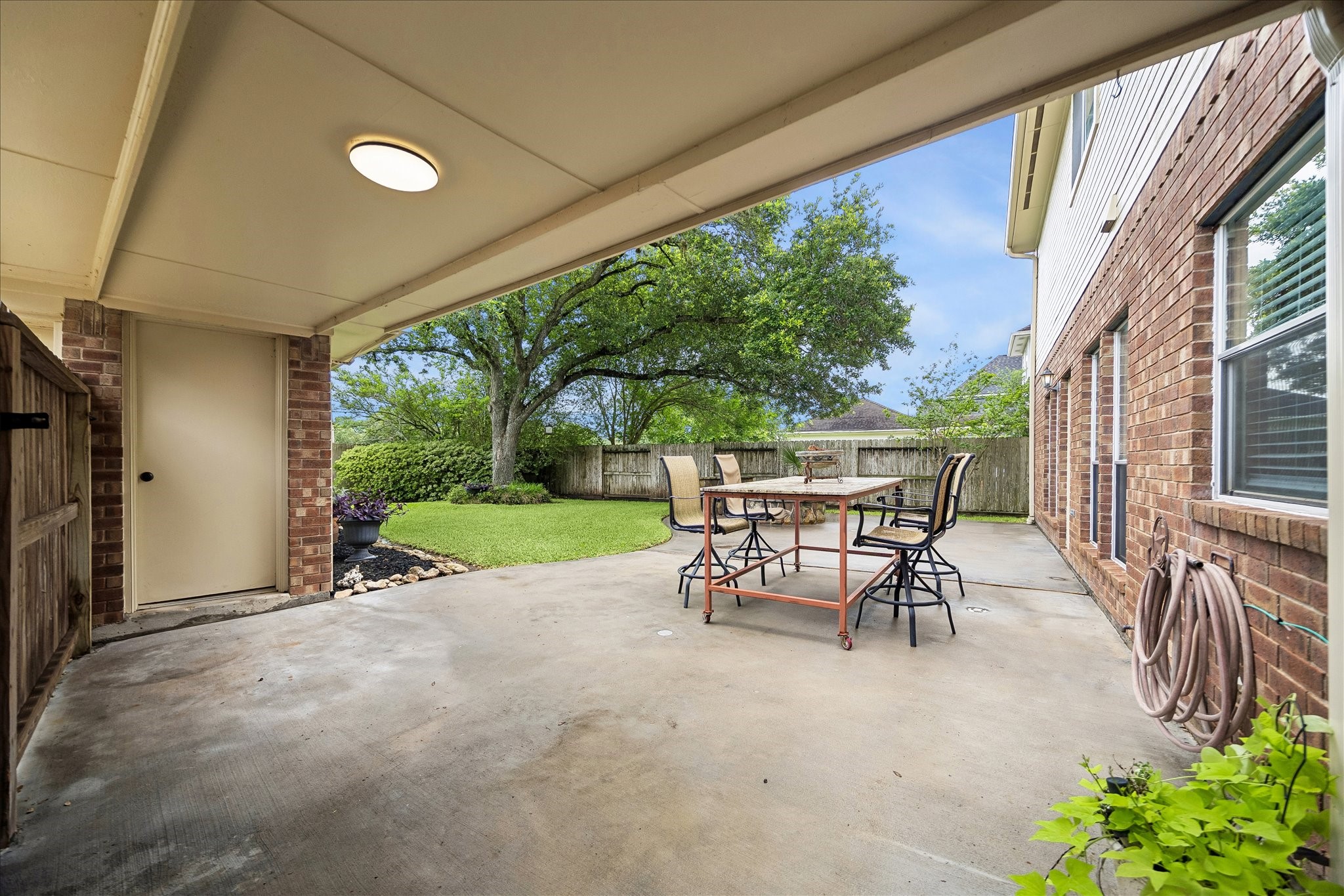 Now, we are walking out the back door from the kitchen.  Covered breezeway to the 2 car garage.  Huge cement patio.