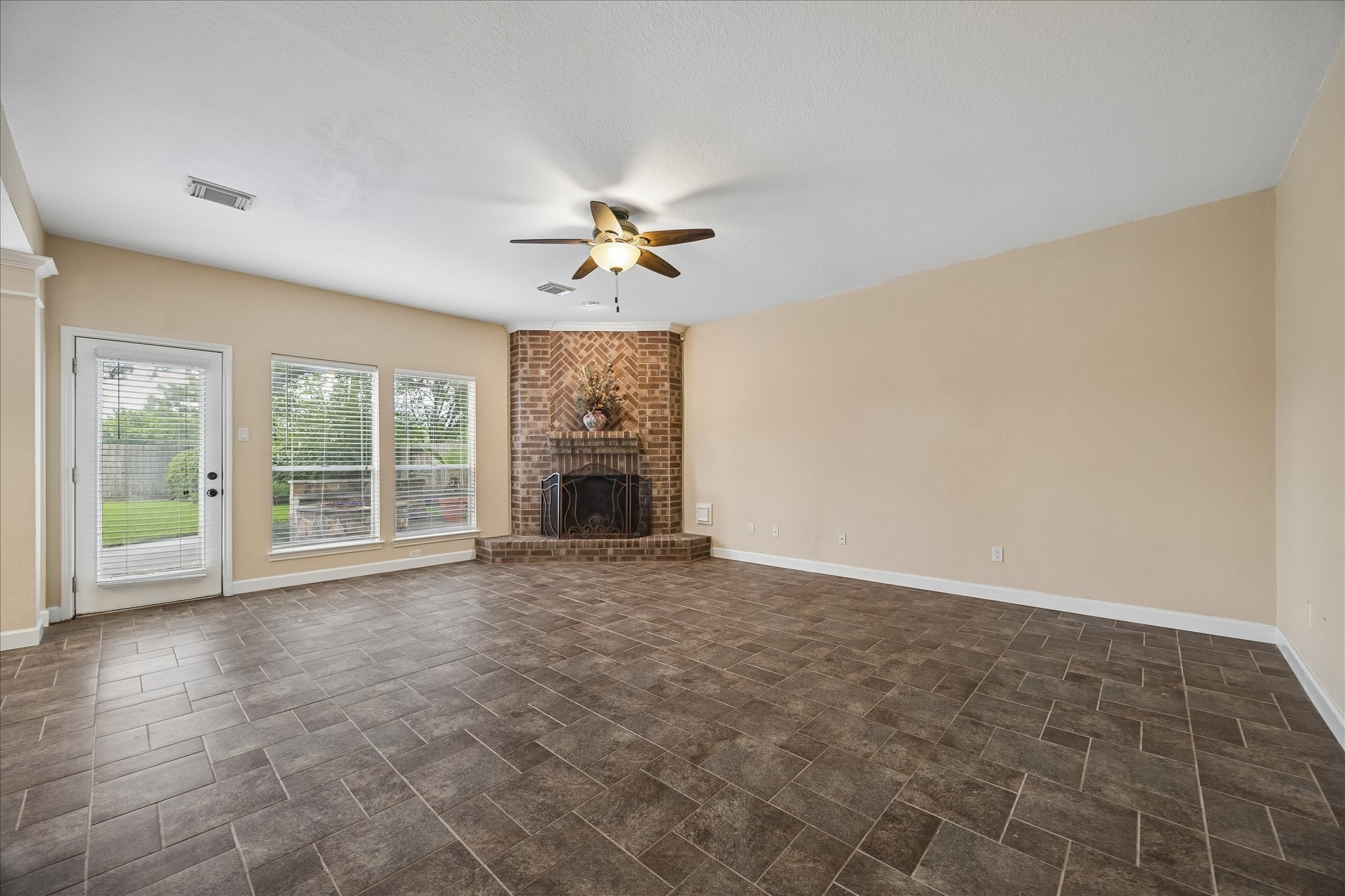 Another view of the family room with elegant brick surround gas fireplace with mantel.  There are 2 doors leading to the backyard - no neighborhs behind!