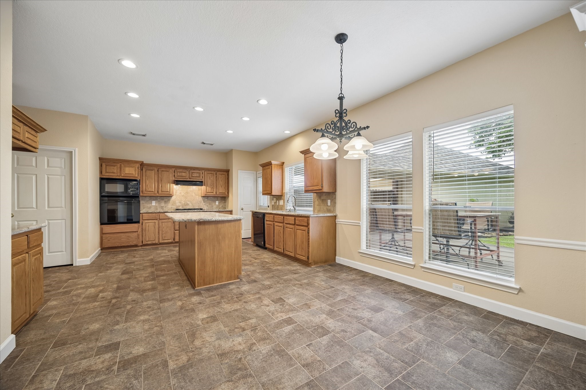 Now lets go from the family room to the breakfast area and then the kitchen.  So many windows to keep it bright.  The back wall features lots of cabinets and storage microwave, convection oven and gas cooktop.