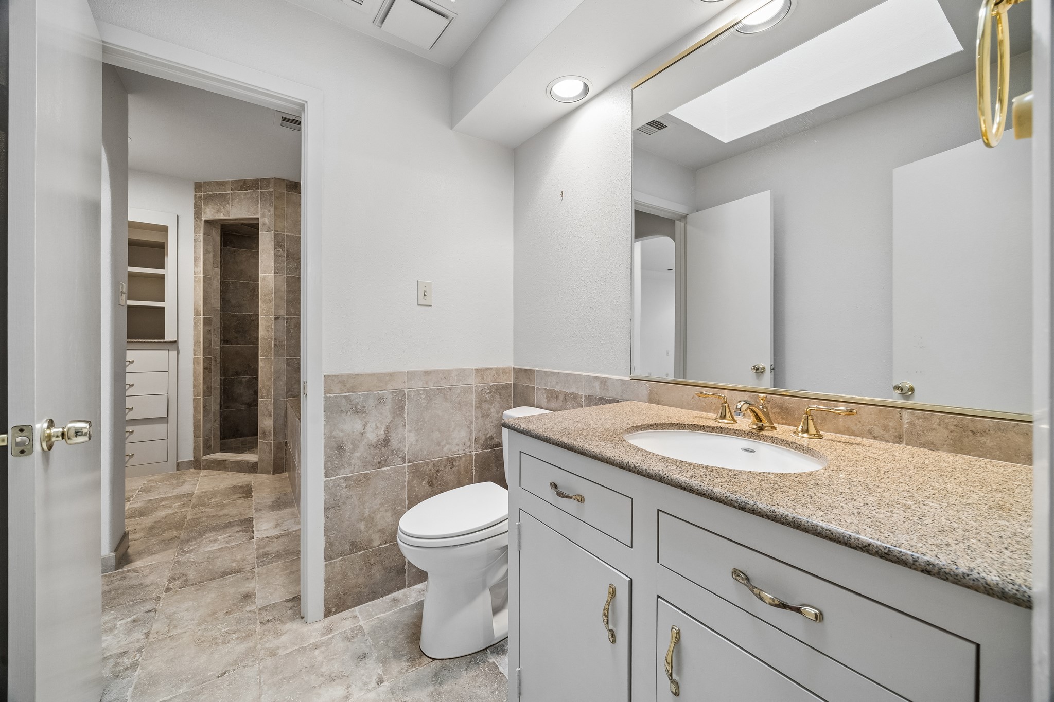 The en-suite bath features stone counter top, large soaking tub and separate shower.