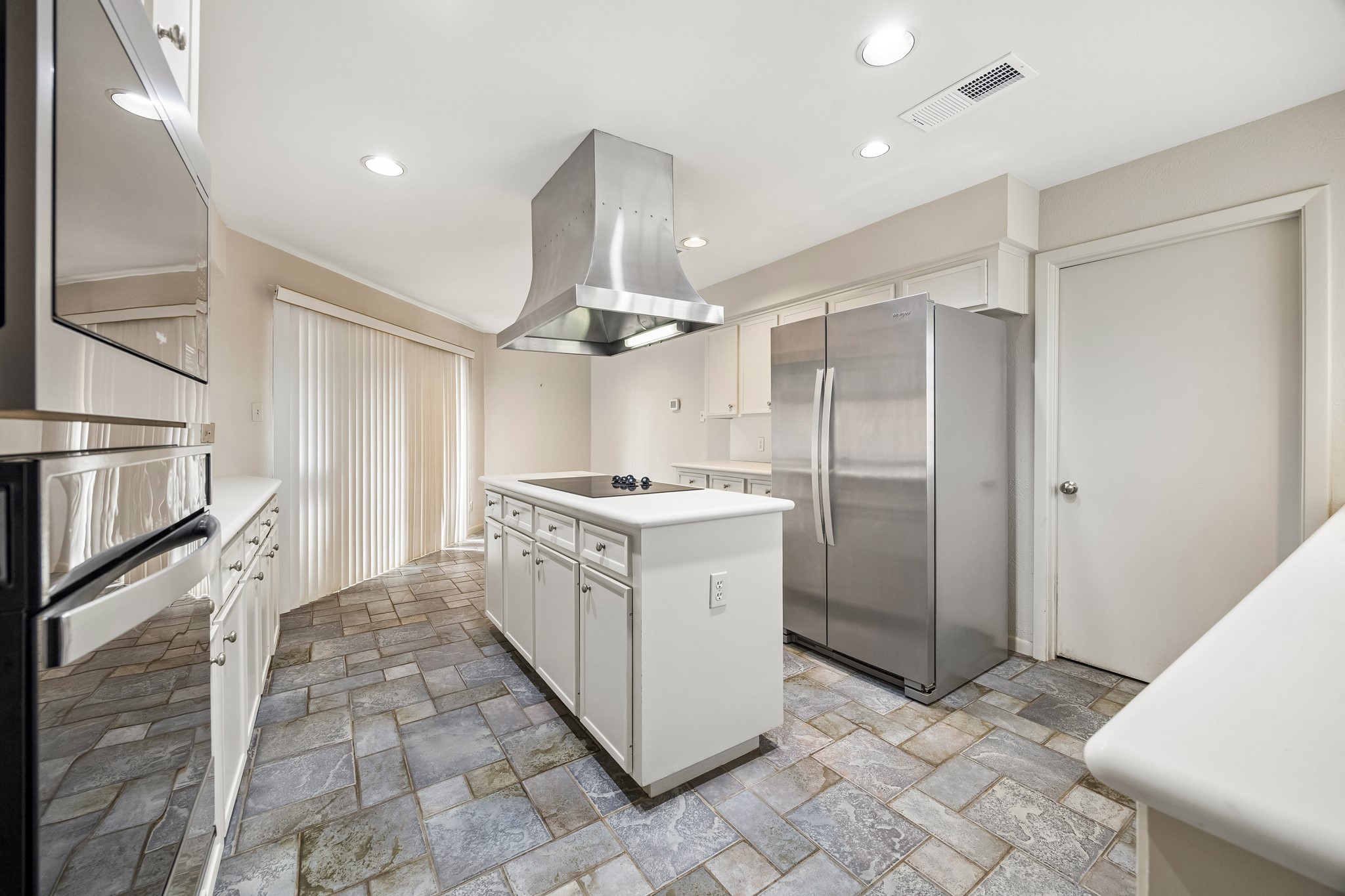 The kitchen island offers abundant storage and breakfast nook with sliding doors to patio.