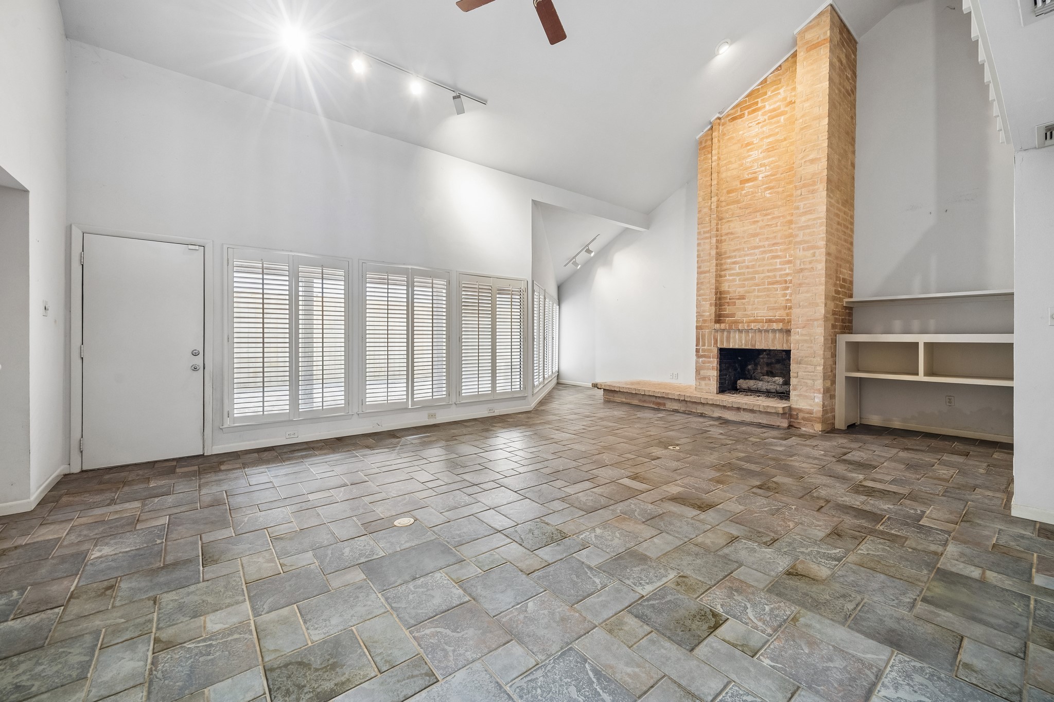 The family room has complete wall of windows, soaring ceilings and lovely natural brick fireplace with gas connections.