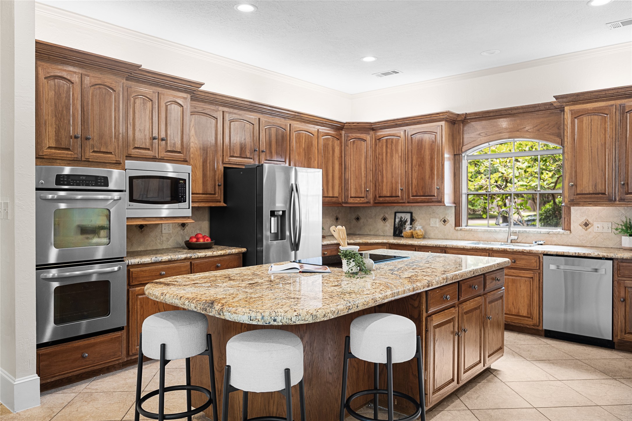 Kitchen offers double ovens, generous prep space, and ample storage.