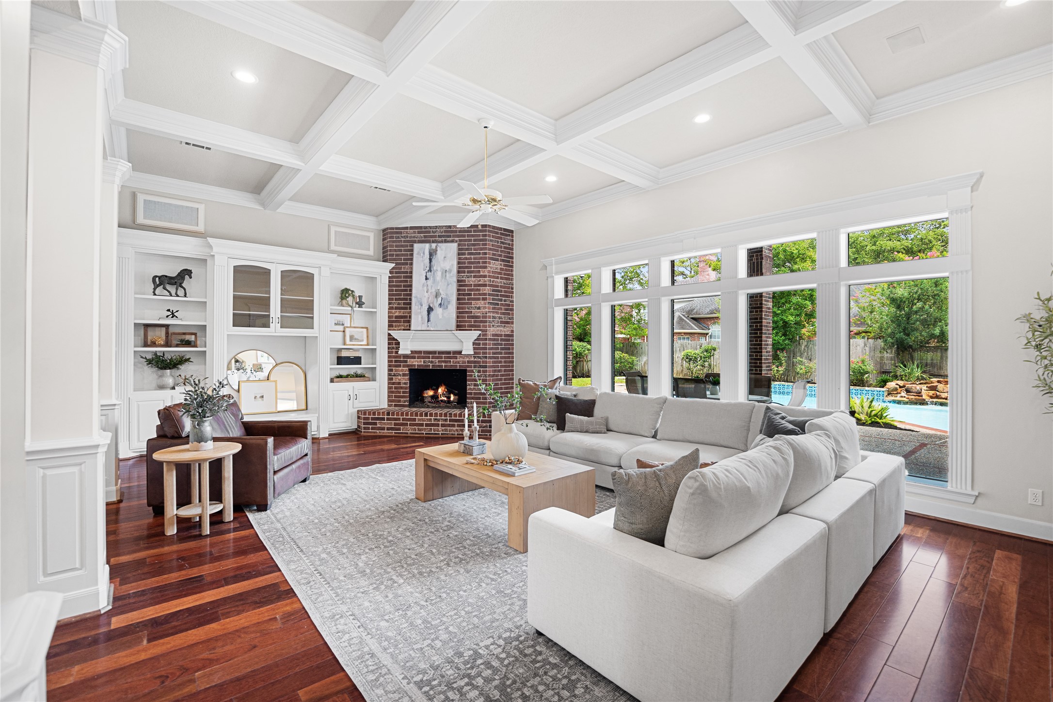 Inviting family room with coffered ceilings, custom built-ins, and fireplace.