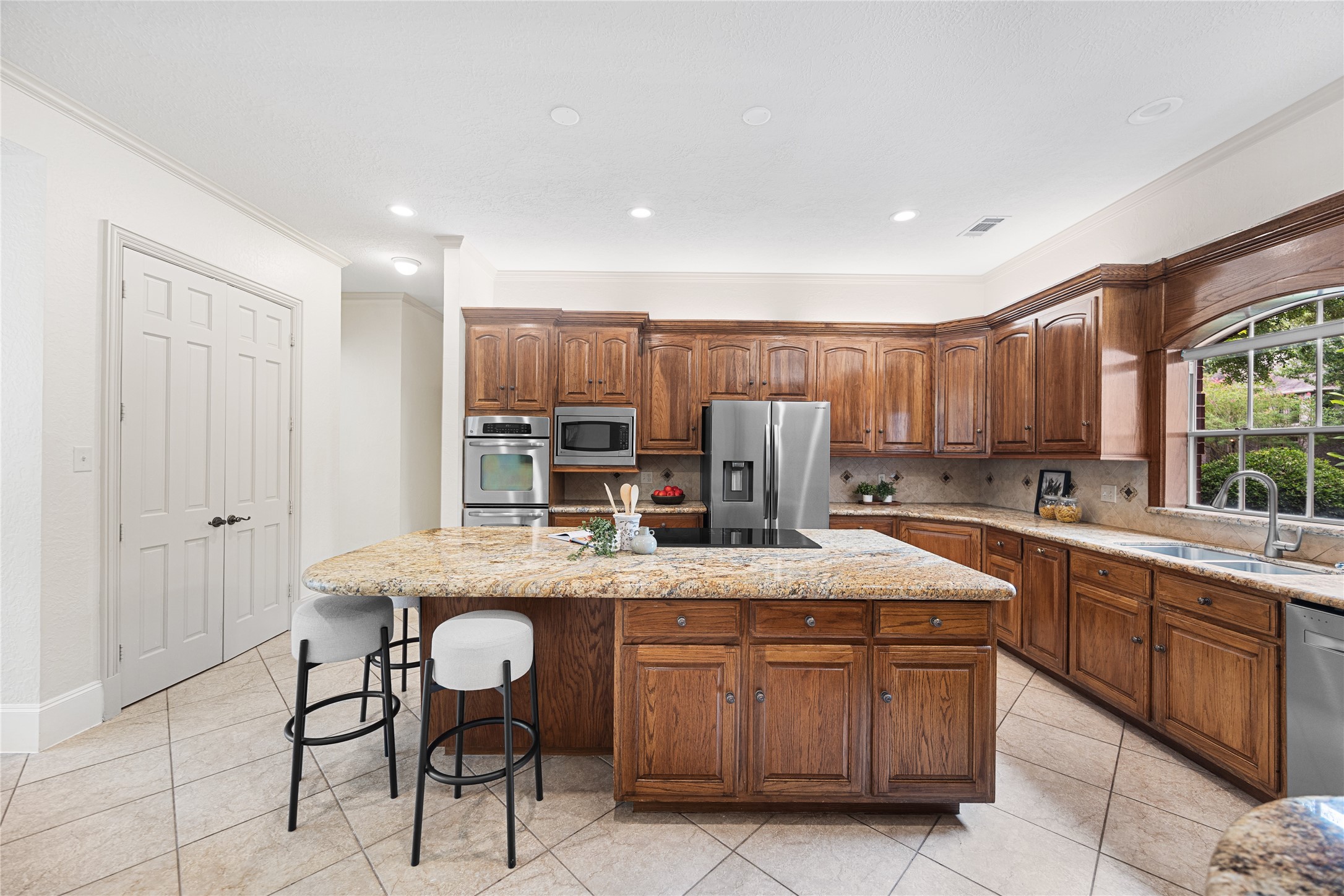Spacious chefs kitchen with oversized granite island and extensive cabinetry.