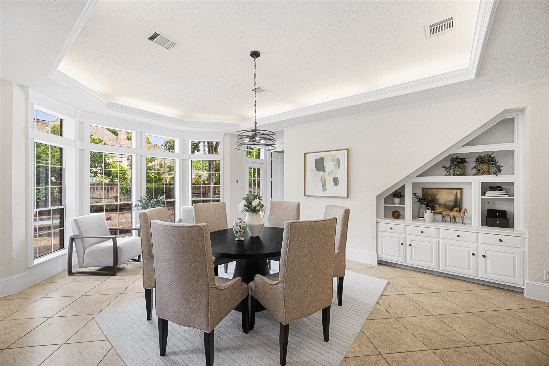 Bright breakfast area with walls of windows overlooking the backyard.
