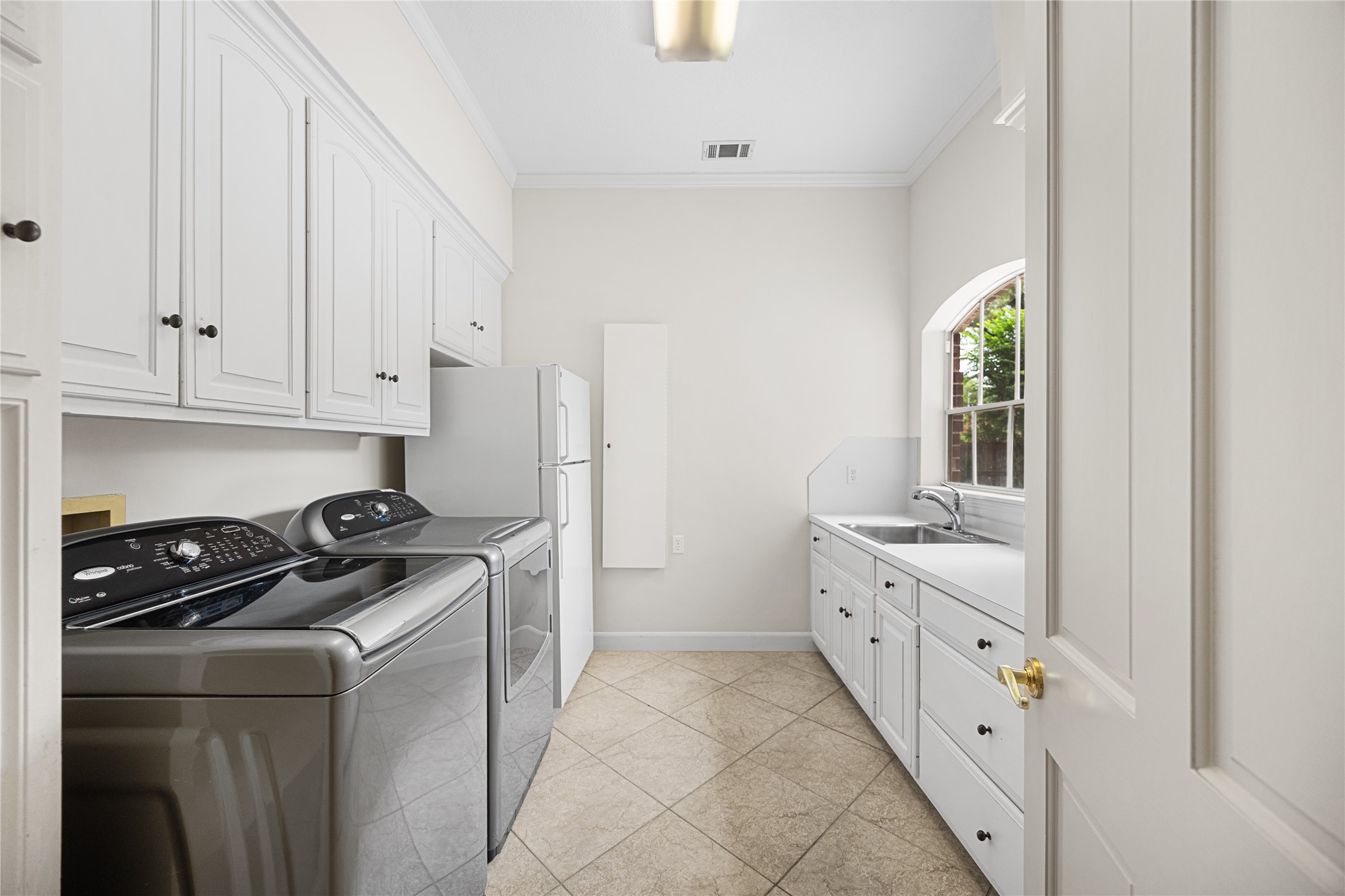 Well-appointed utility room with extensive cabinetry and workspace.