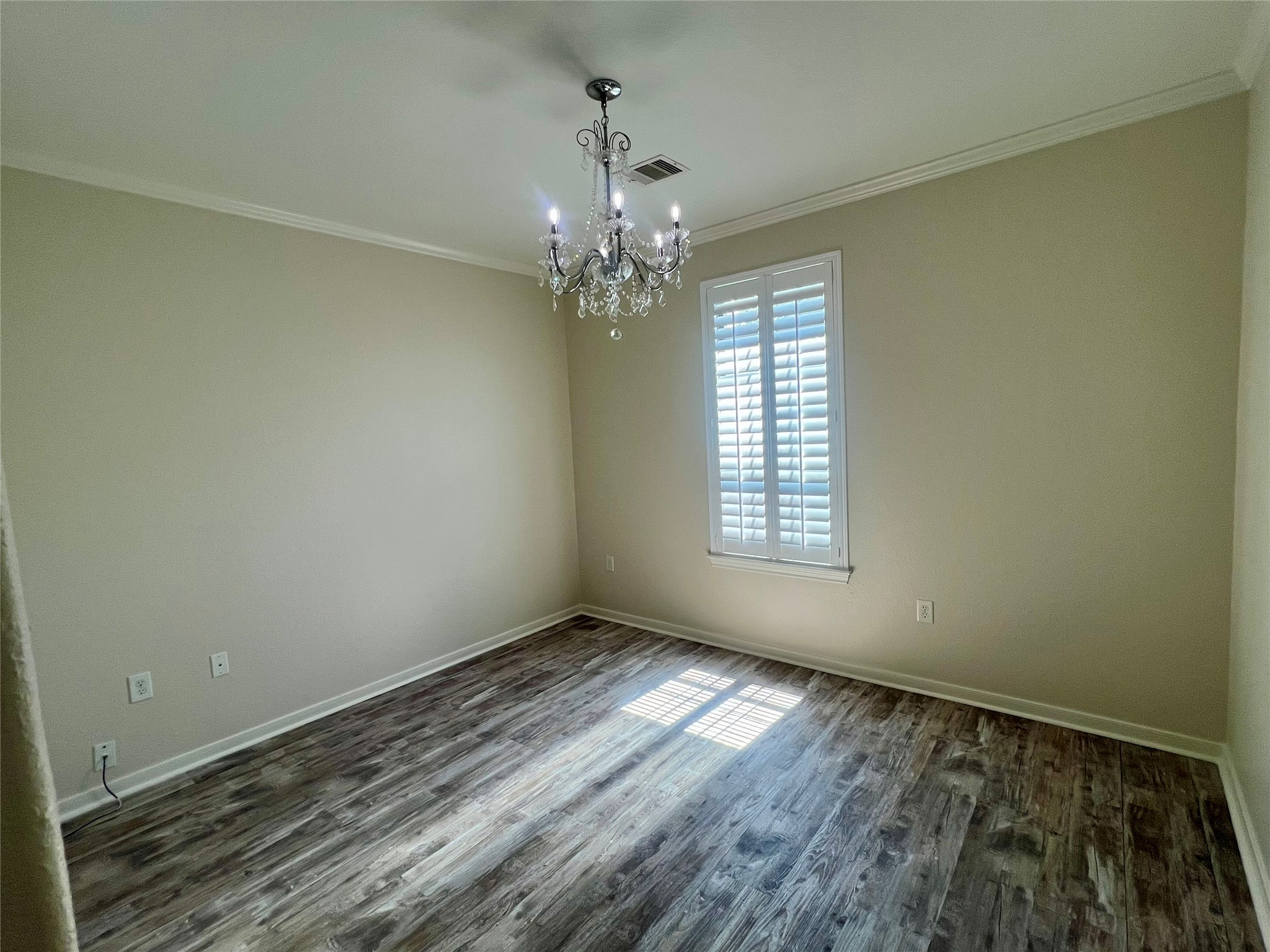 Front bedroom with nice chandelier and plantation shutters.