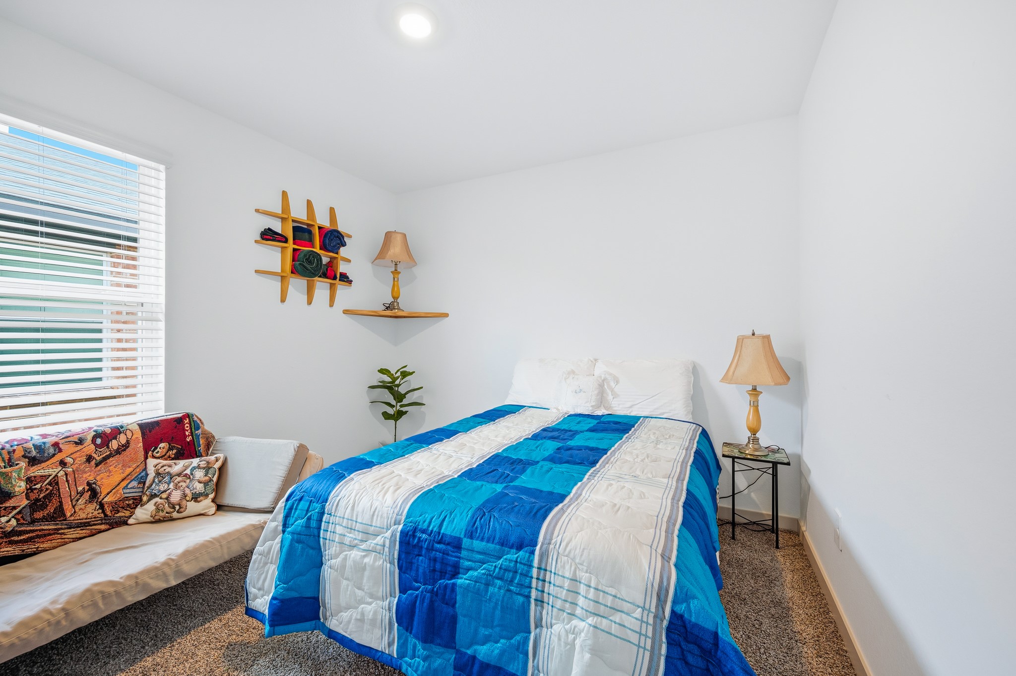 Cozy primary bedroom with a bright window. The room is carpeted for added warmth.