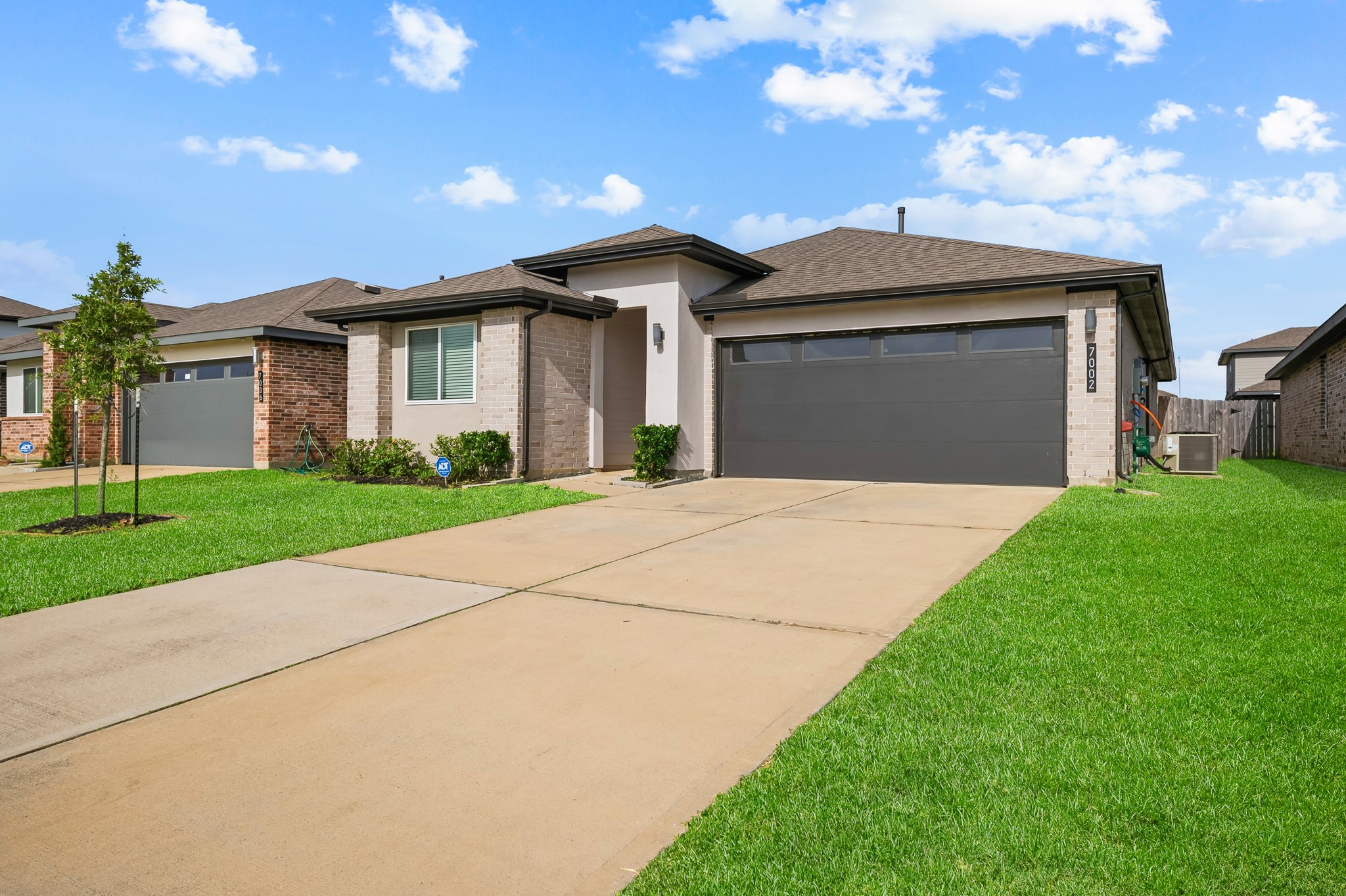 Modern single-story home with a clean facade, featuring a two-car garage, well-maintained front yard, and a tidy driveway.