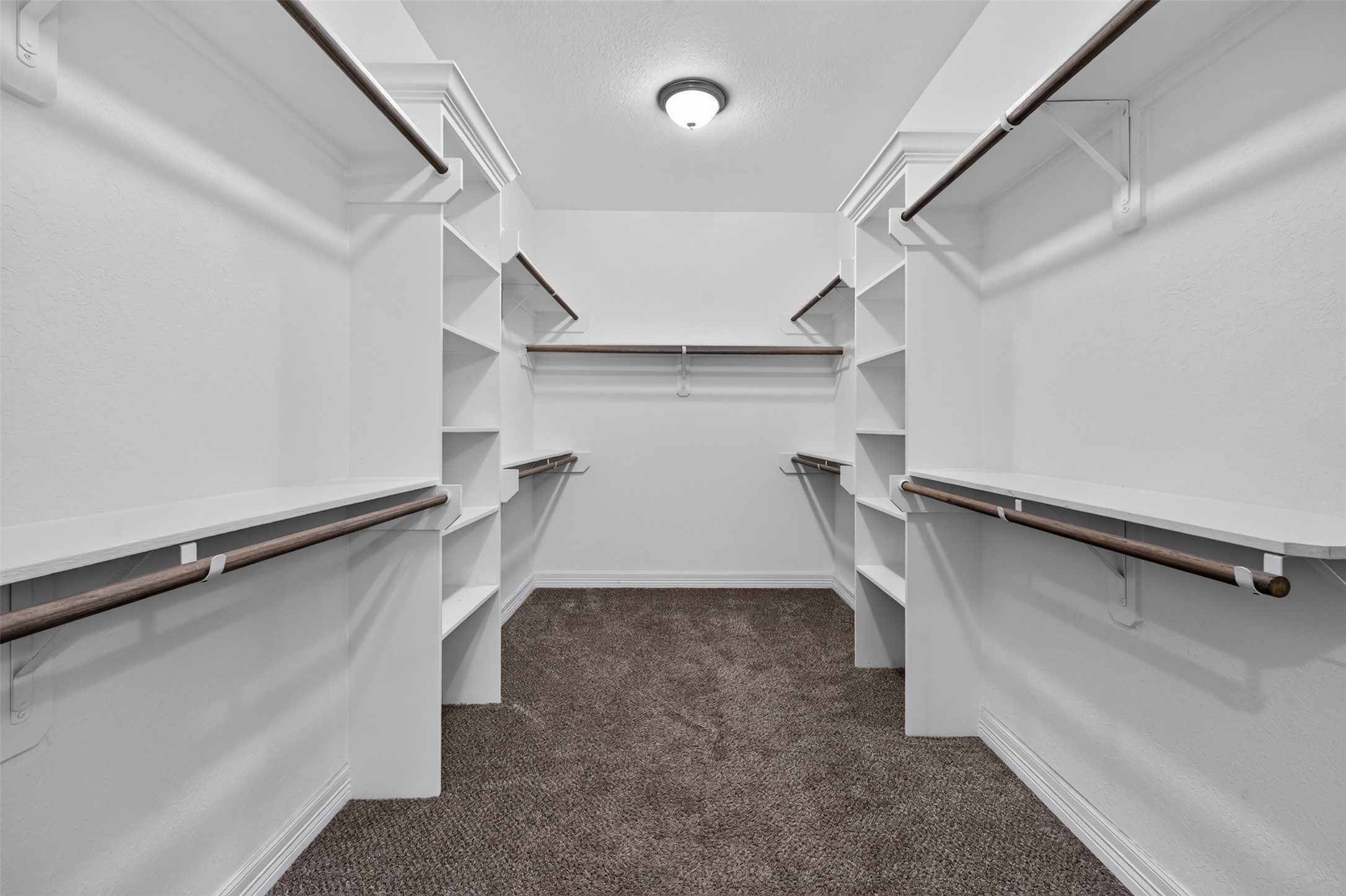 Expansive walk-in closet featuring ample shelving and hanging space, perfectly designed for organized storage.