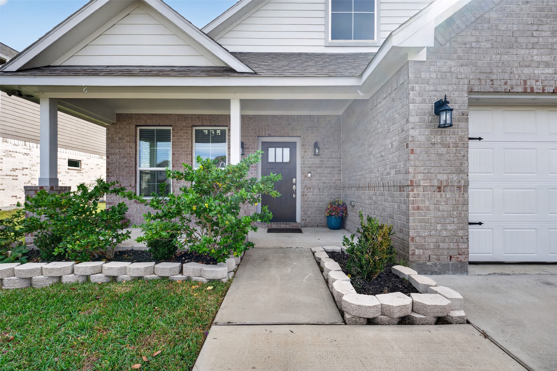 Charming brick home with a welcoming front porch, landscaped garden beds, and a stylish entryway. Charming brick home with a welcoming front porch, landscaped garden beds, and a stylish entryway.