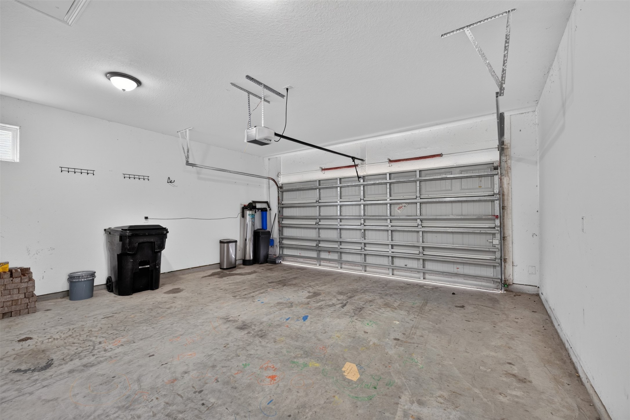 Spacious two-car garage with ample room for storage, featuring a durable concrete floor and convenient shelving for organization.