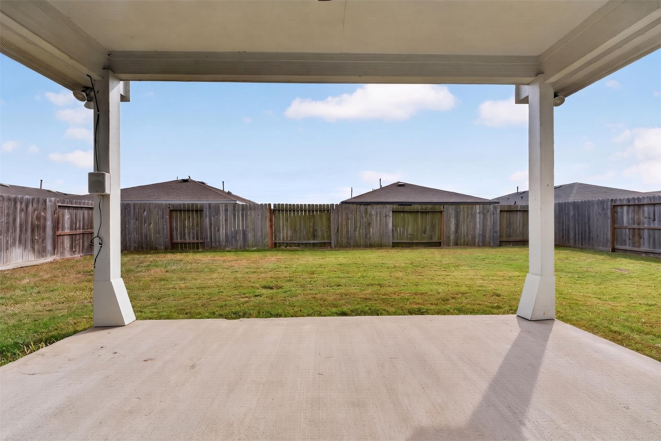 Spacious backyard with a covered patio, ideal for outdoor gatherings and relaxation.
