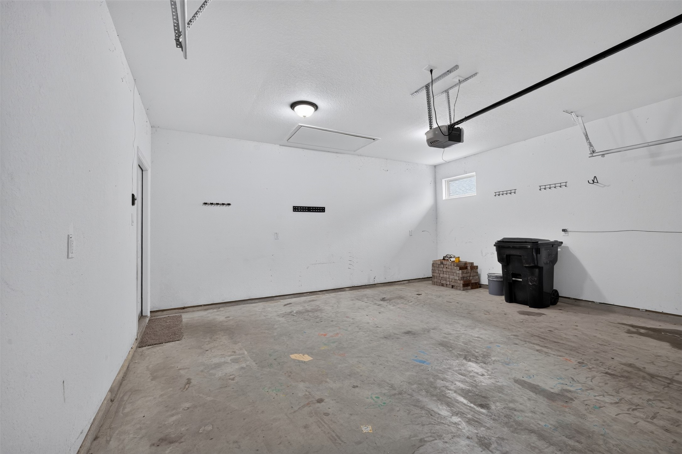 Spacious garage with ample room for storage and parking, featuring a clean, finished interior and overhead lighting.
