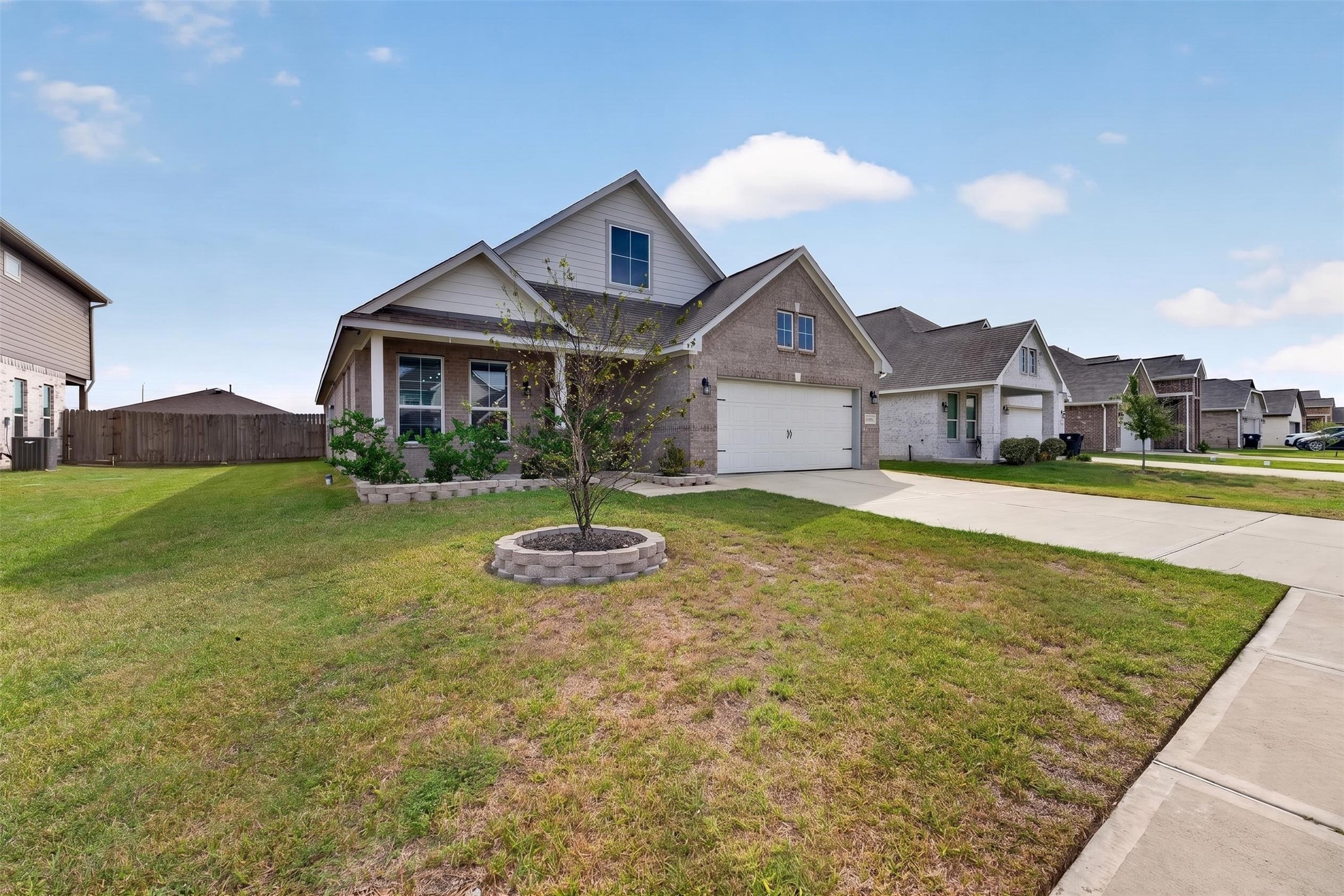 Charming two-story home with a welcoming front porch, spacious driveway, and well-maintained lawn, nestled in a quiet neighborhood.