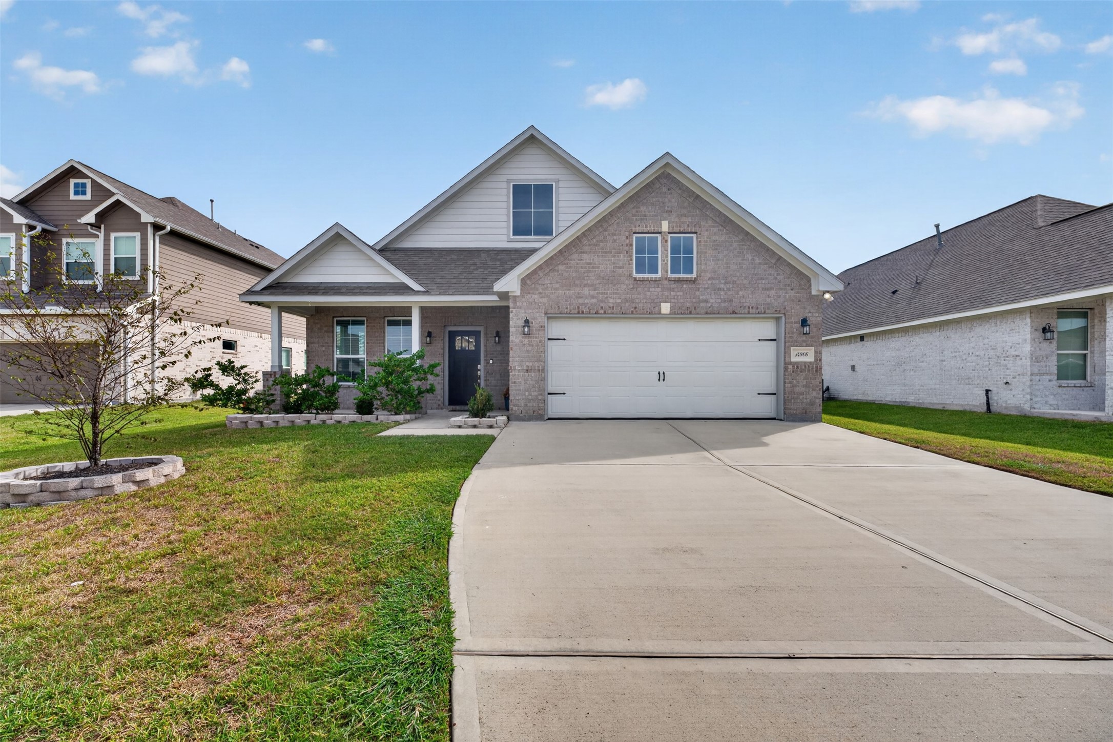 Charming two-story home with a welcoming brick facade, spacious driveway, and manicured front yard, offering great curb appeal in a serene neighborhood.