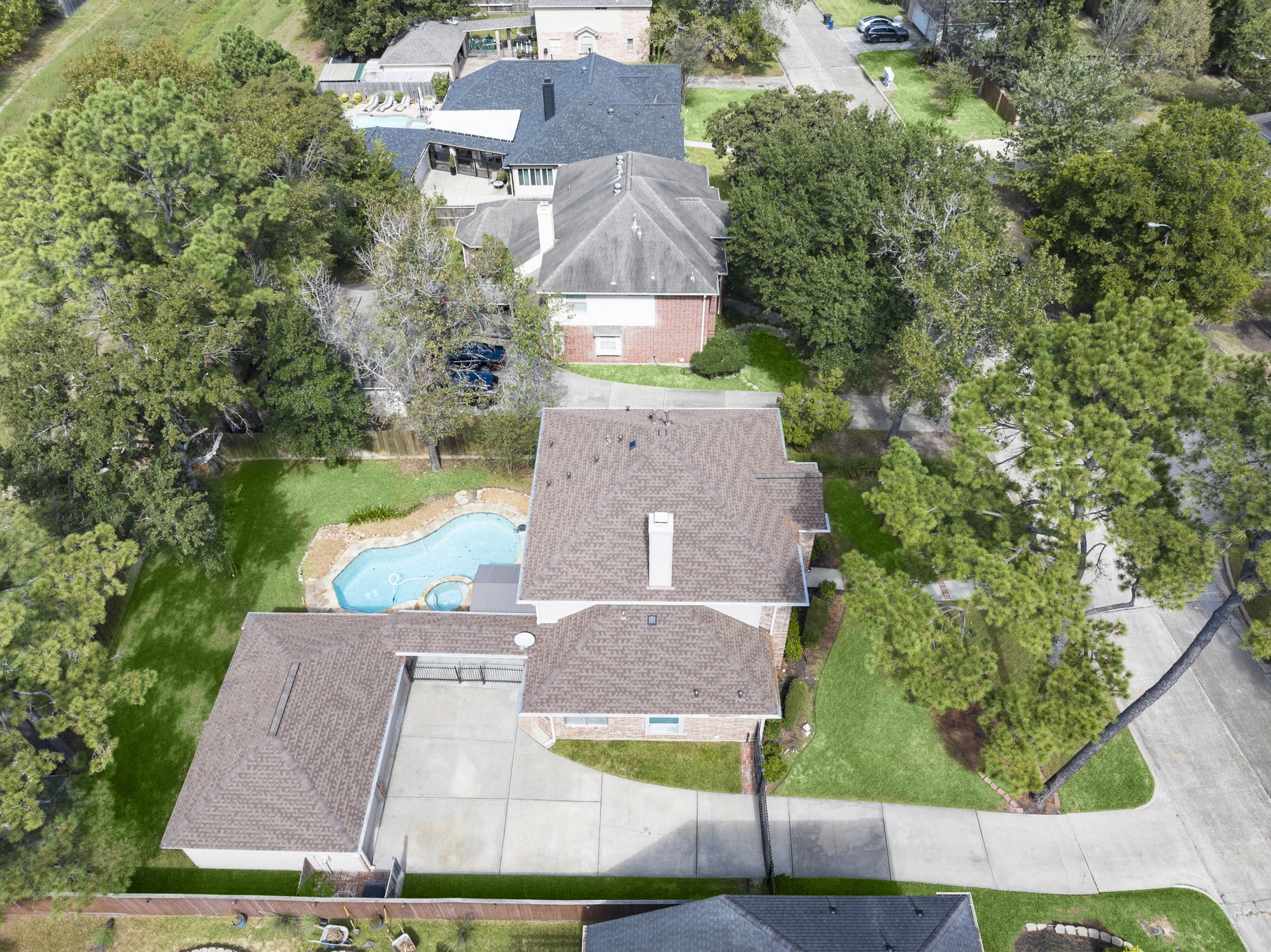 NOW THAT'S CURB APPEAL FROM ABOVE! Just look at that gorgeous newer roof, expansive driveway with room for multiple vehicles, and beautiful canopy of mature shade trees! The gated drive provides added privacy, while lush landscaping and generous green space surround this beautifully situated home. A picture-perfect setting from every angle!