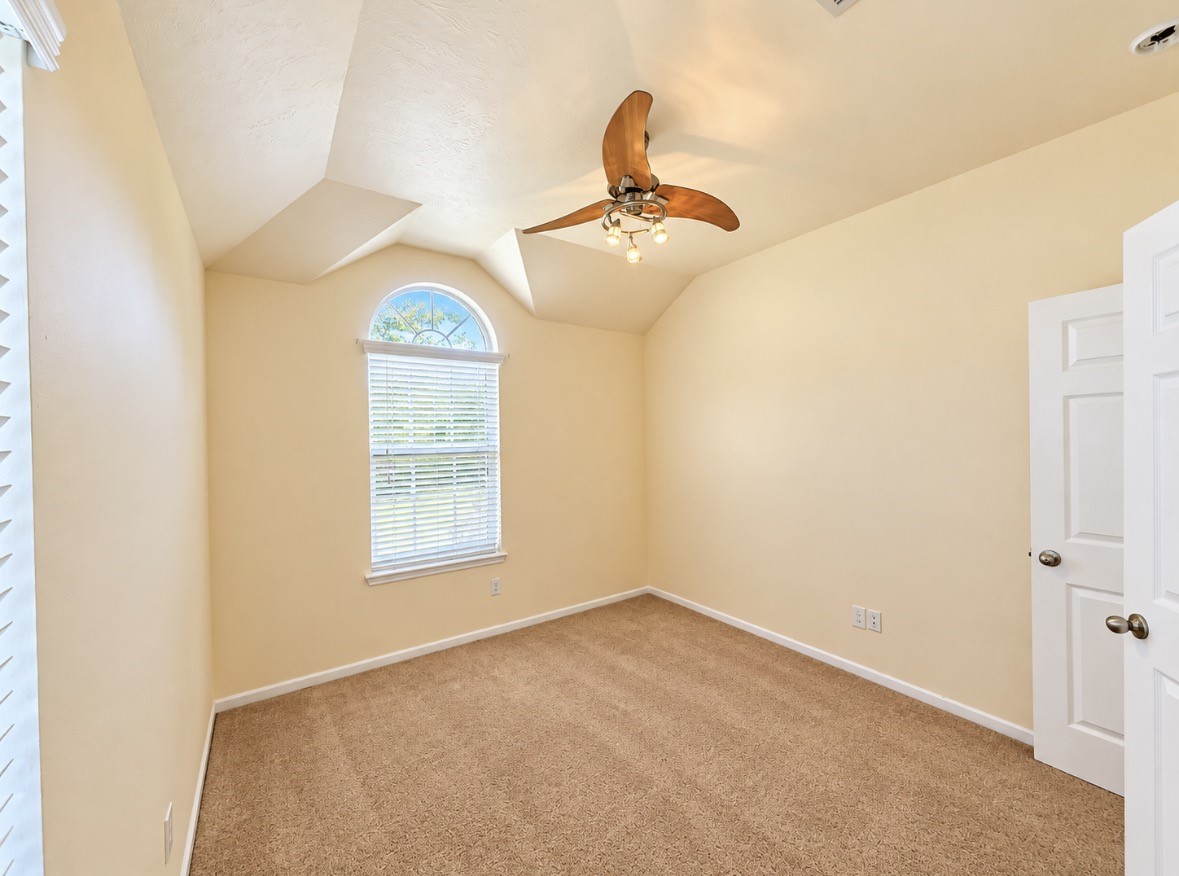 Lovely bedroom with vaulted ceiling, beautiful arched window & distinctive architectural character.