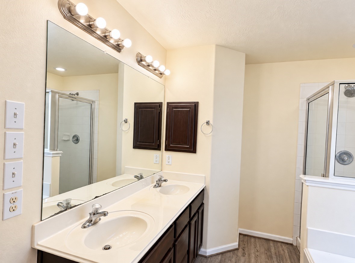 En-suite bathroom featuring dual sinks, generous vanity space & a separate shower.