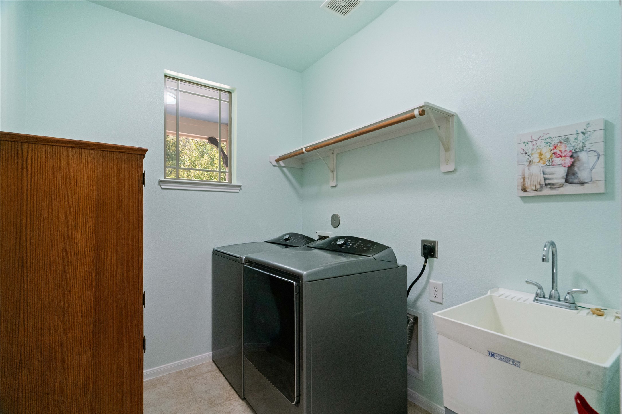 Even laundry day feels a little easier with a dedicated utility room featuring cabinet storage and a convenient sink!