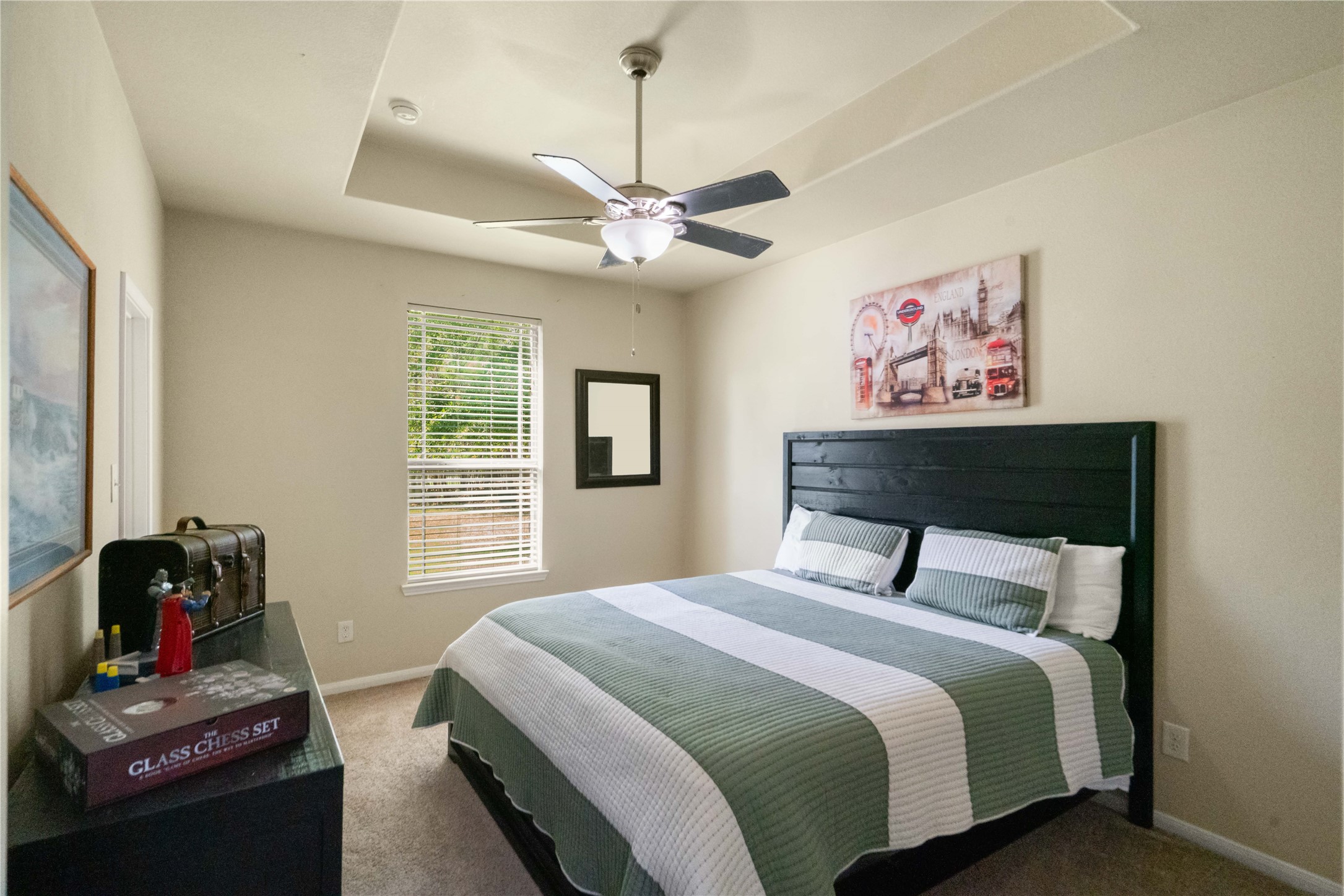 A welcoming bedroom with a lovely tray ceiling and natural lightyour guests will feel right at home!