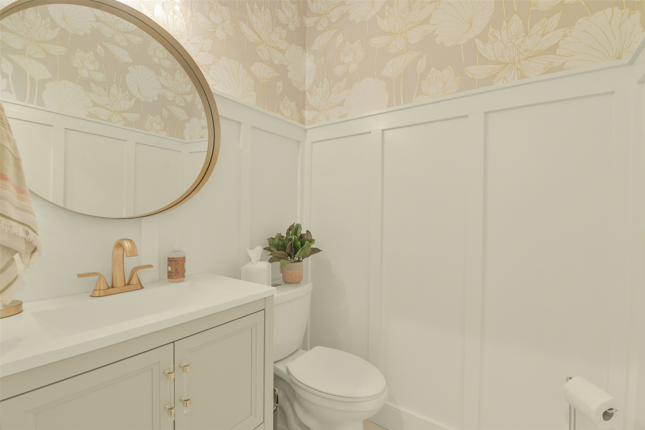 Beautifully appointed powder bathroom featuring decorative wall finishes and a stylish vanity.