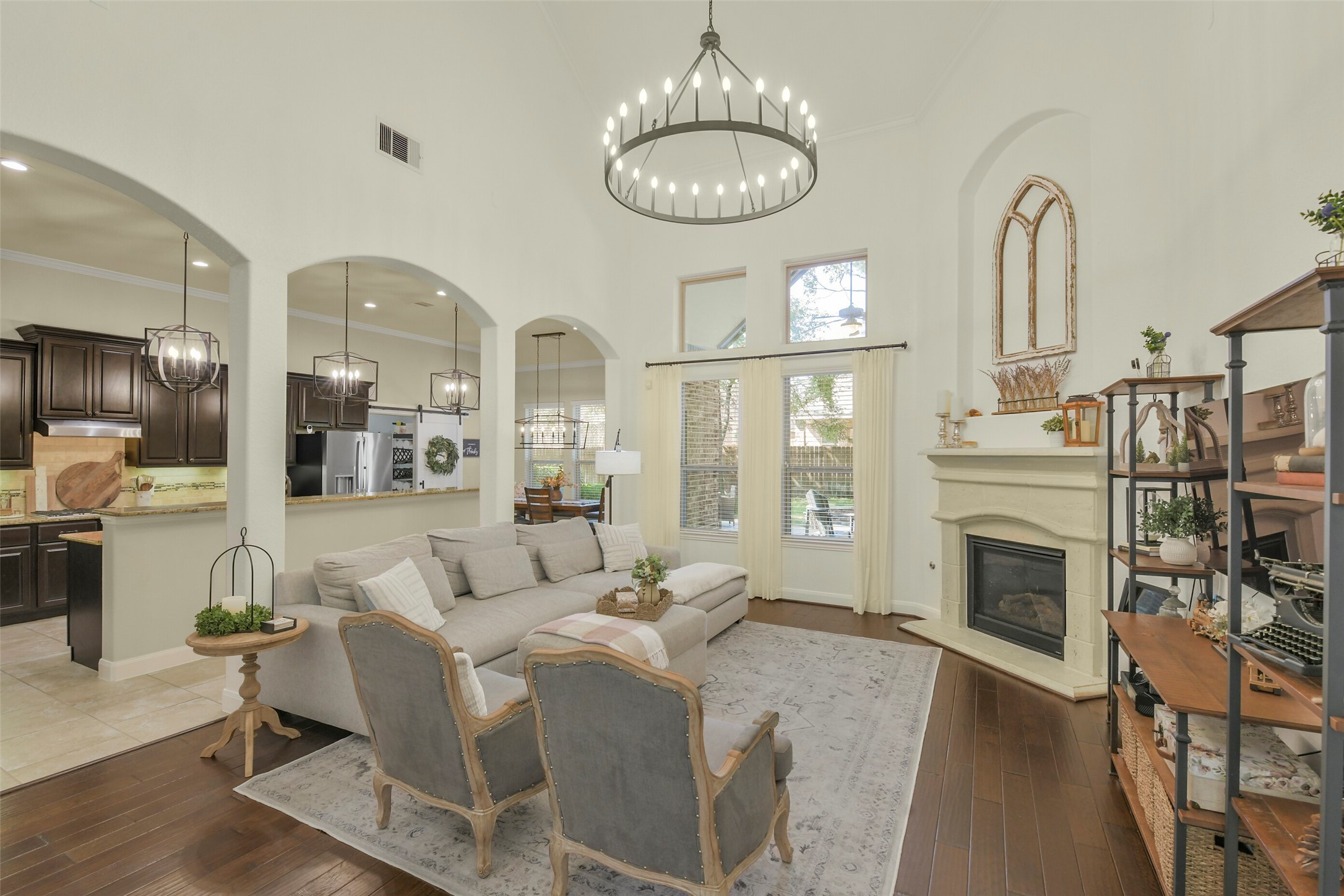 Spacious family room with soaring ceilings, fireplace, and an open layout connecting to the kitchen.