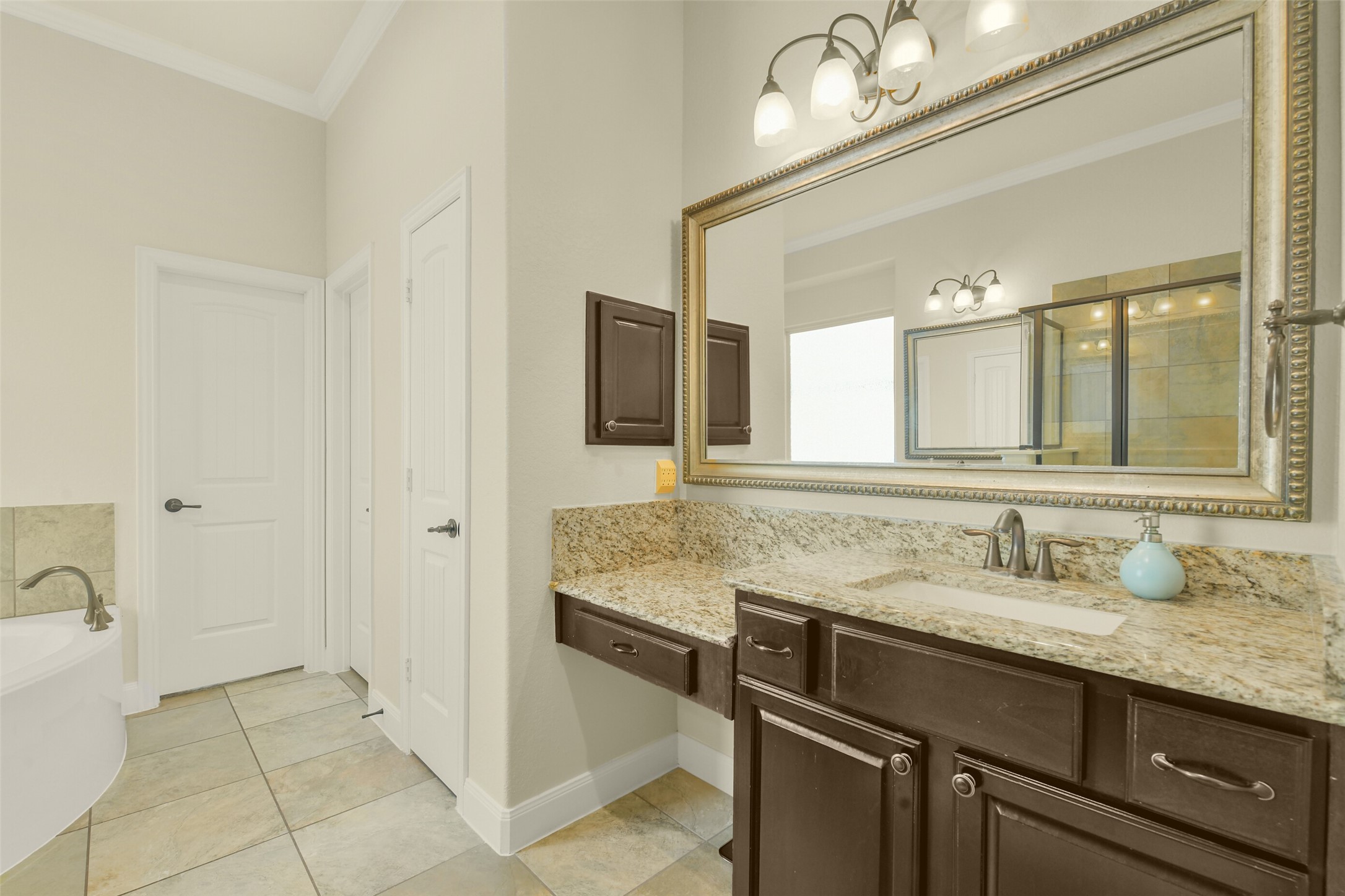 Dual vanities with generous counter space, framed mirrors, and ample cabinetry.
