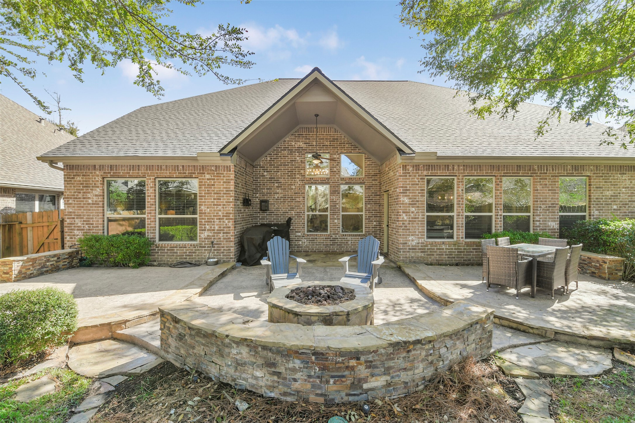 Stunning rear elevation showcasing the home's brick exterior, outdoor living areas, and attractive landscaping.