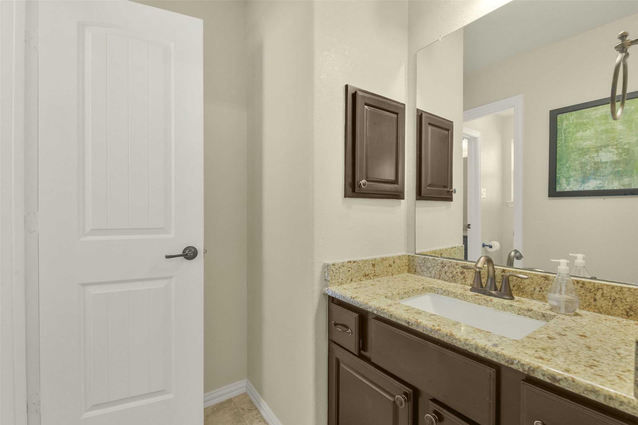 Additional bathroom with attractive vanity, framed mirror, and neutral finishes.