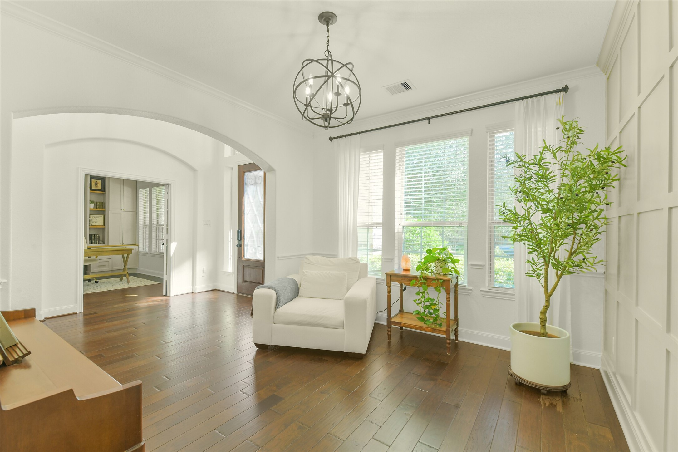 Elegant primary suite featuring hardwood flooring, large windows, and a comfortable sitting area.